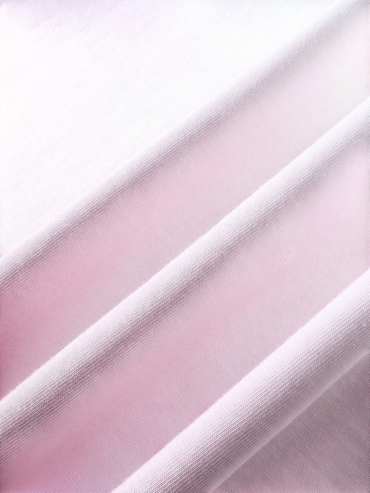 Close-up of the pink dip-dye wash on TBHNP white arrival short-sleeve tee — men's streetwear detail