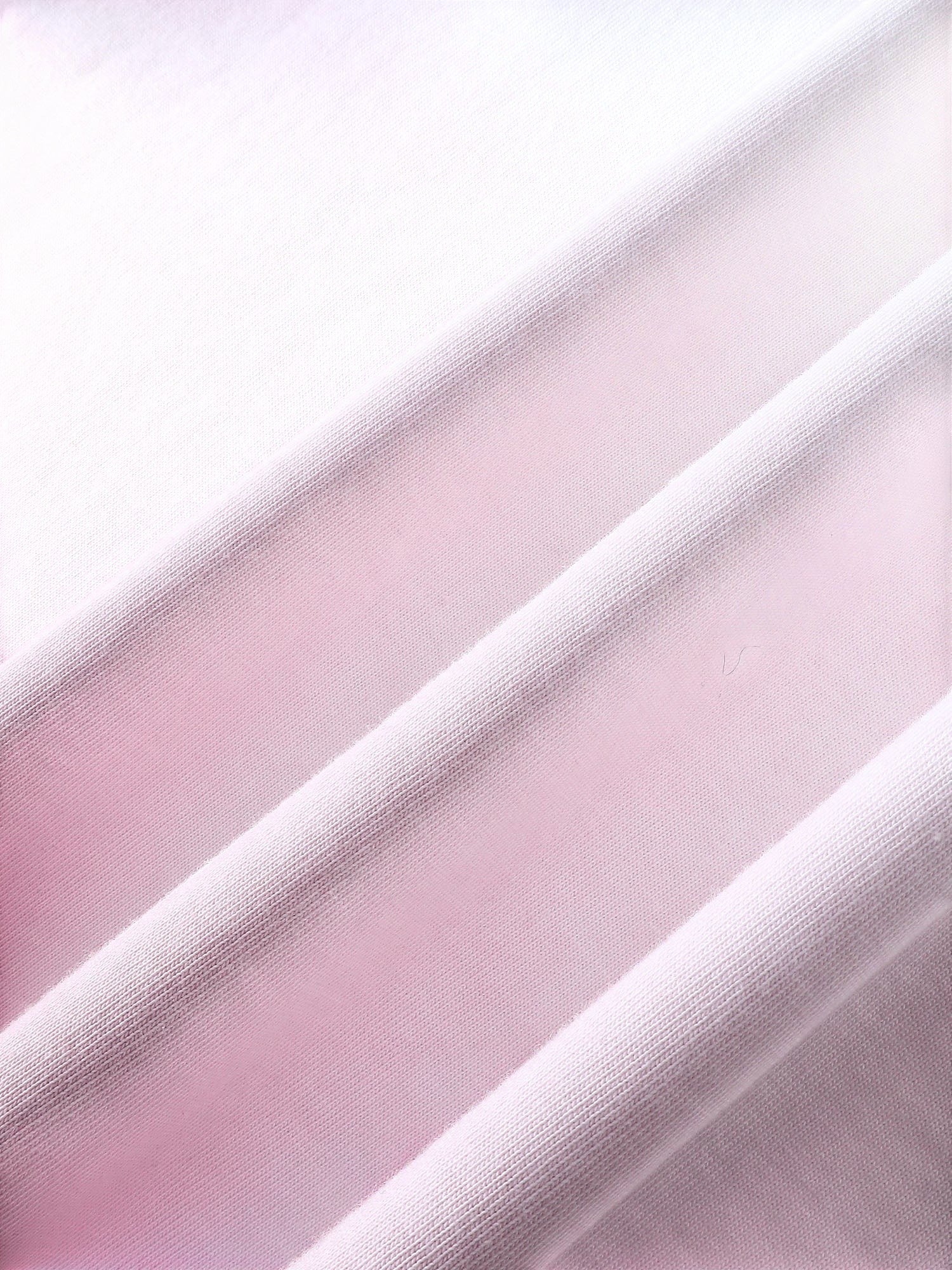 Close-up of the pink dip-dye wash on TBHNP white arrival short-sleeve tee — men's streetwear detail