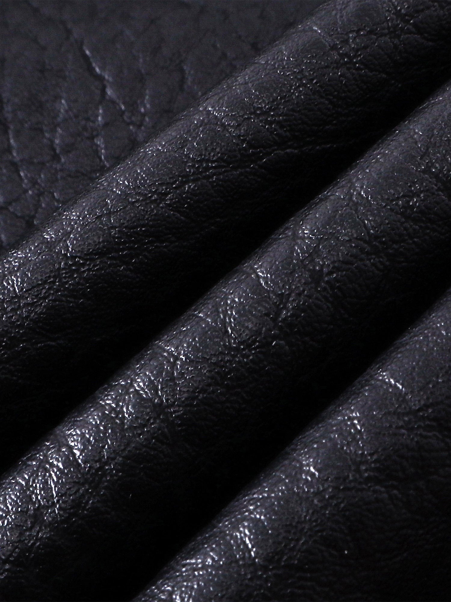 Close-up of the faux-leather texture on TBHNP Luminous Dawn shorts — men's streetwear detail