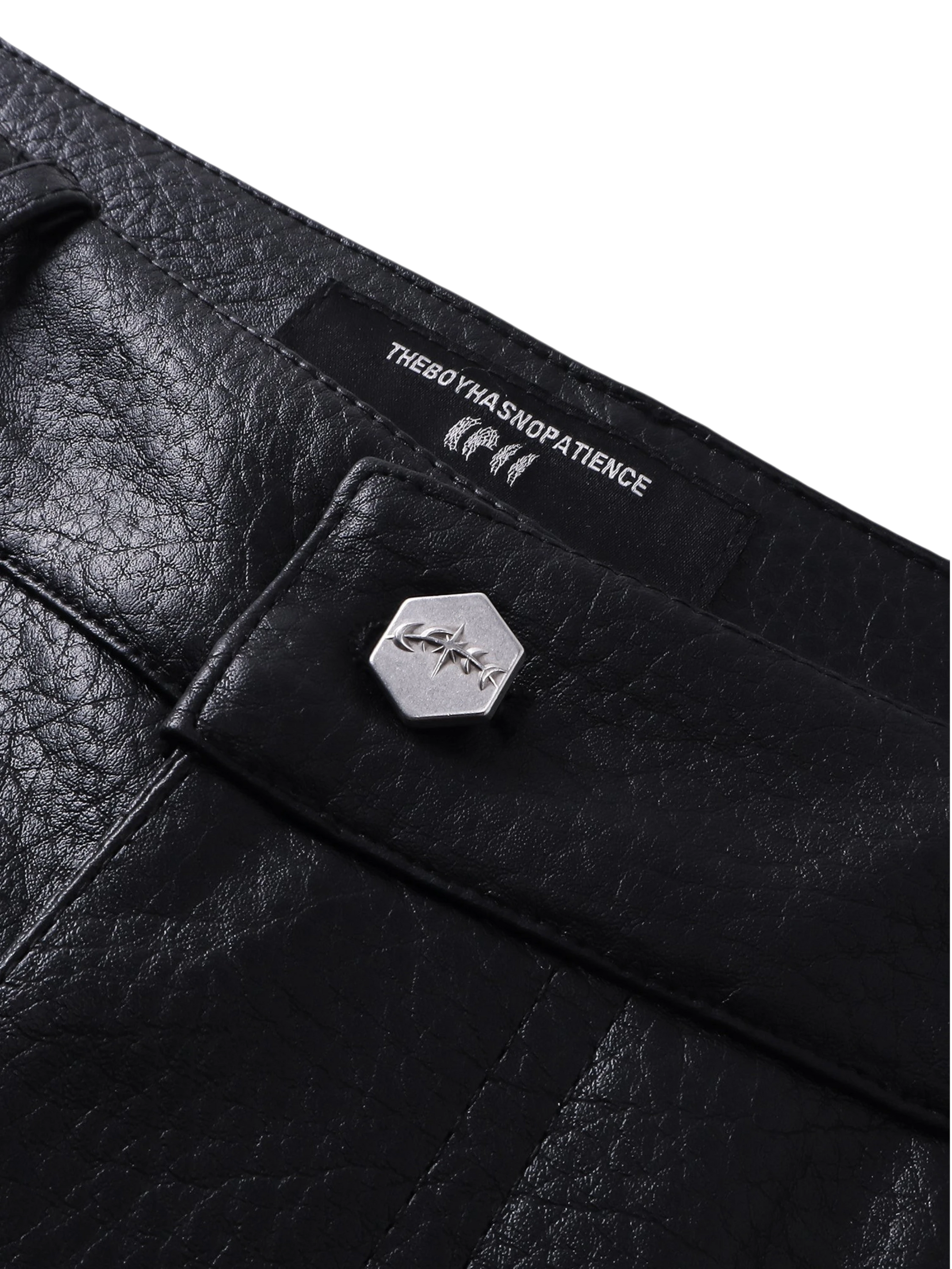 Close-up of the metal hardware on TBHNP faux-leather shorts — men's streetwear detail