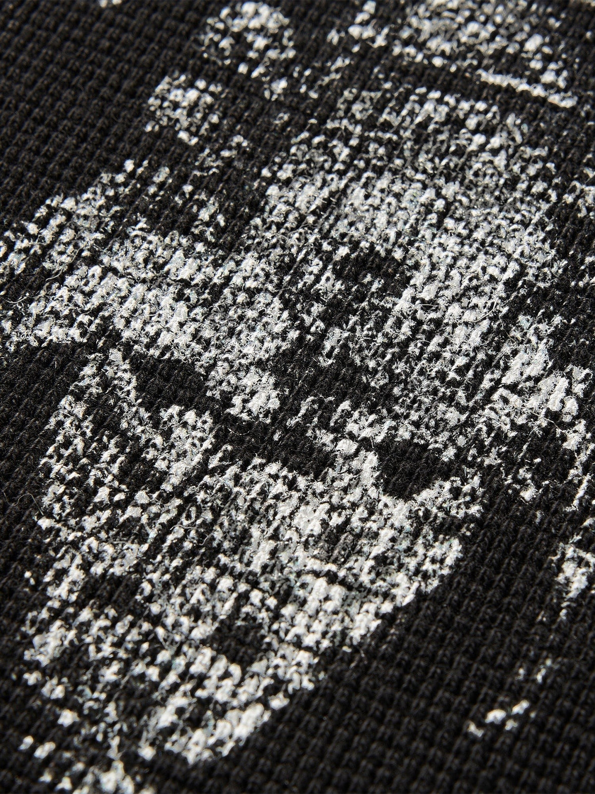 Close-up of the sword-and-bone print on TBHNP black waffle-knit tee — men's streetwear detail