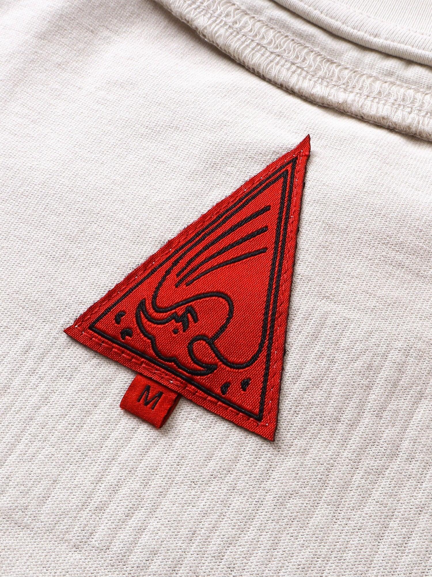 Close-up of the crescent-moon print on TBHNP grayish-yellow knight tee — men's streetwear detail