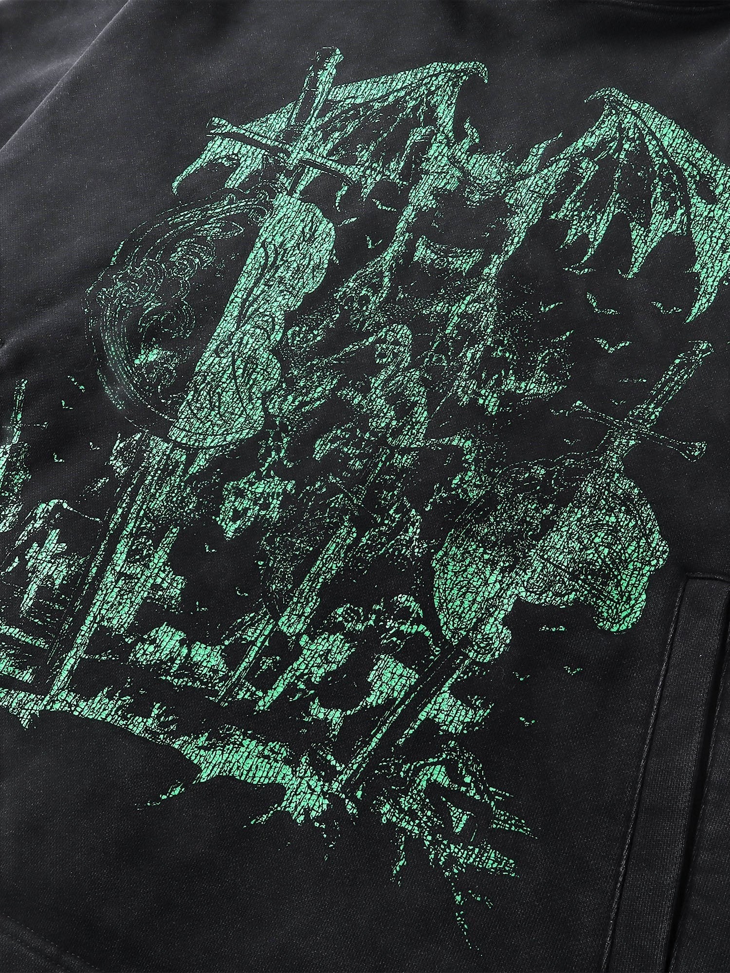 Close-up of the teal knight print on TBHNP black hoodie — men's streetwear detail
