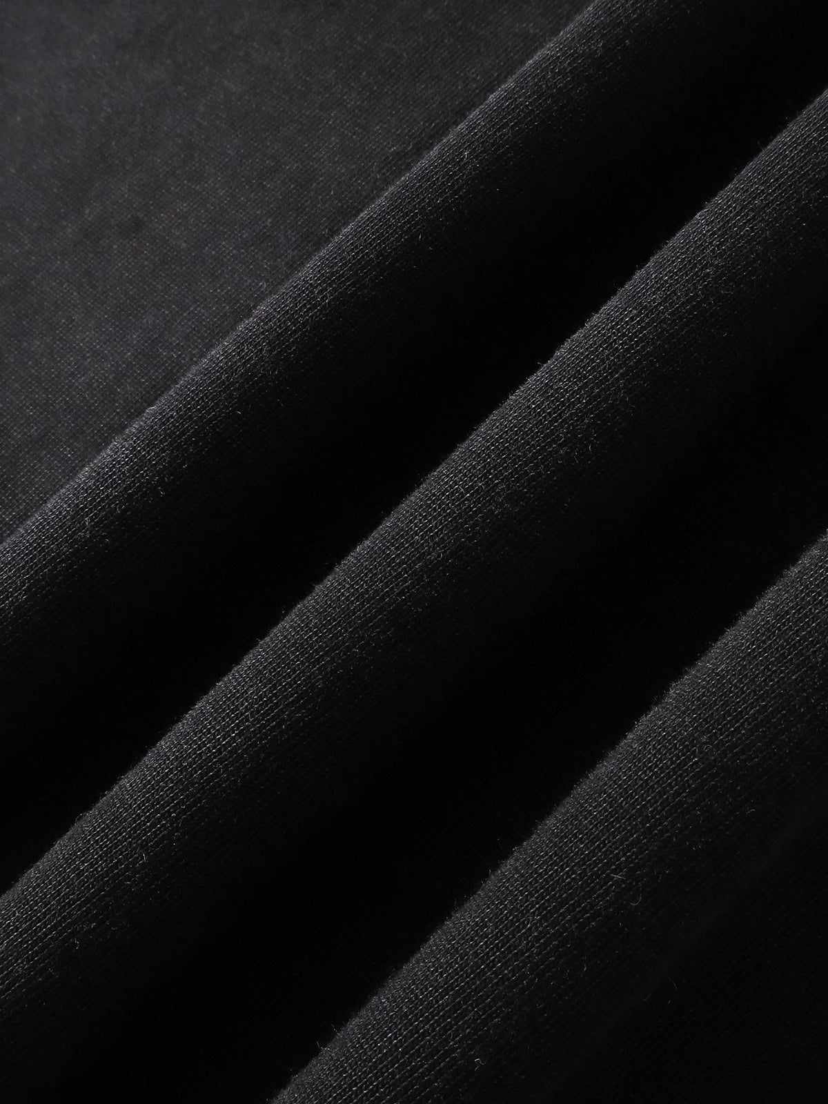 Close-up of the cotton fabric texture on TBHNP black arrival tee — men's streetwear detail