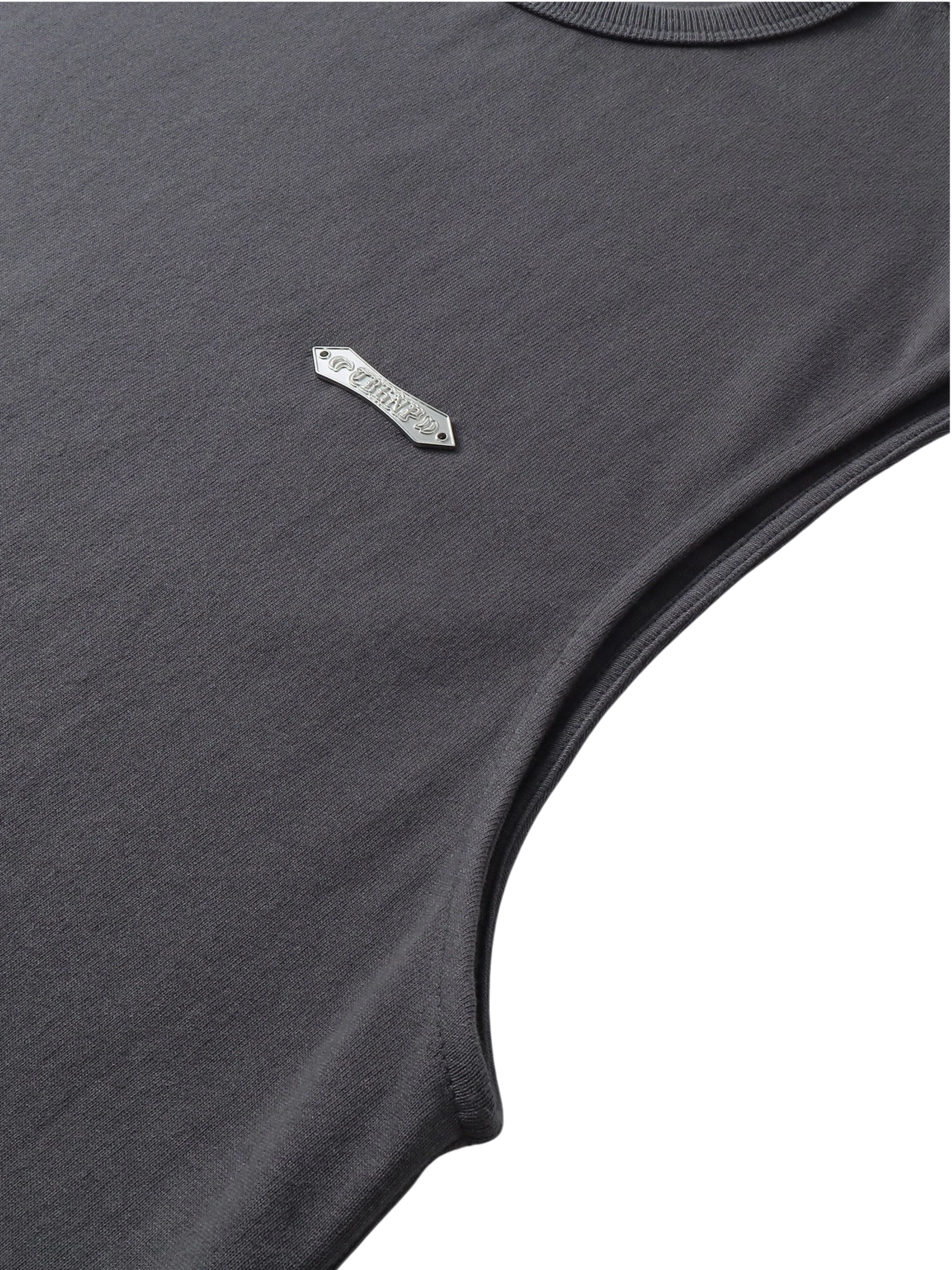 Close-up of the metal logo label on TBHNP dark grey Shadowbat vest — men's streetwear detail