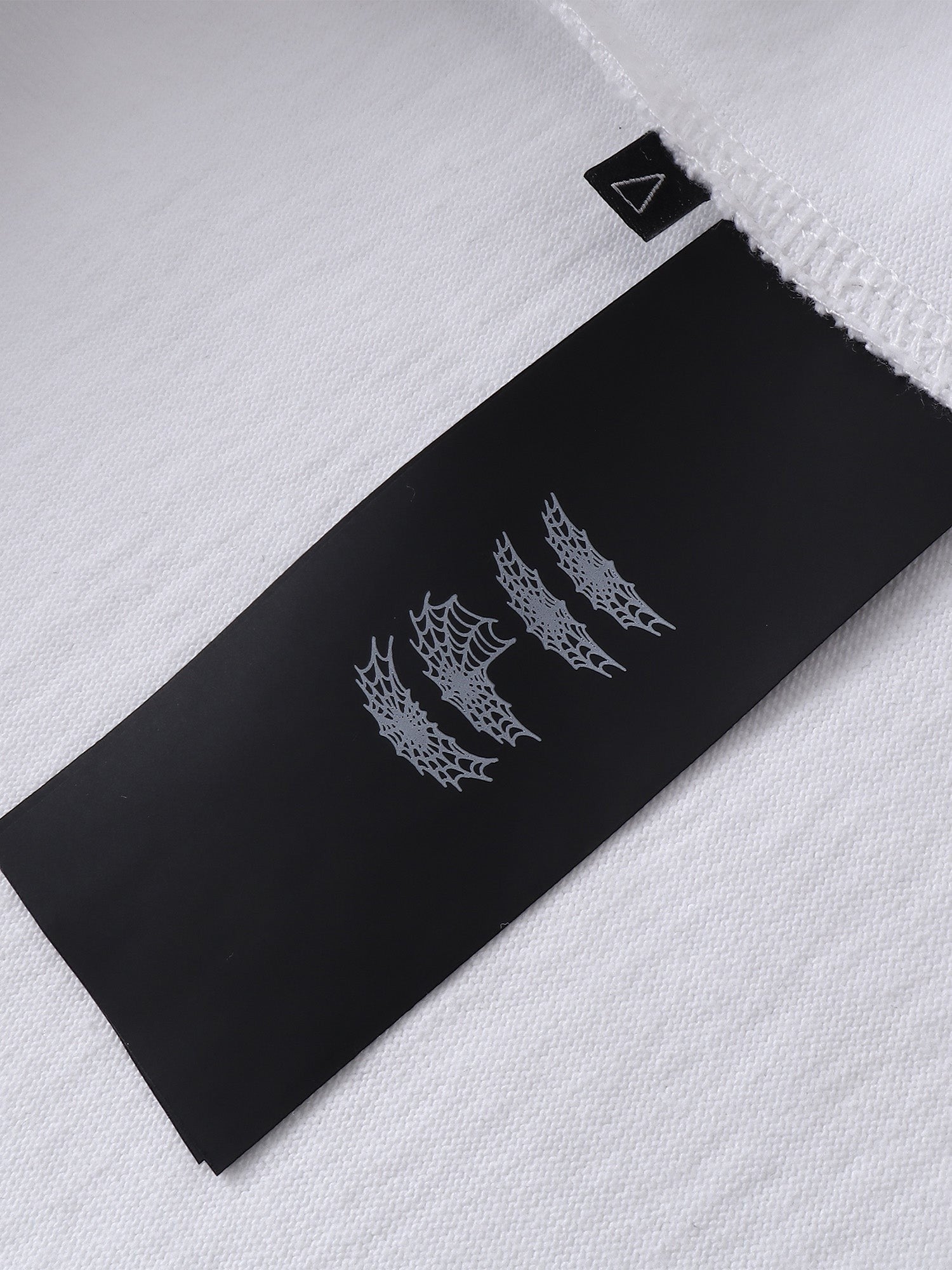 Close-up of the cotton fabric on TBHNP dark grey Emblem & Shadowbat tee — men's streetwear detail
