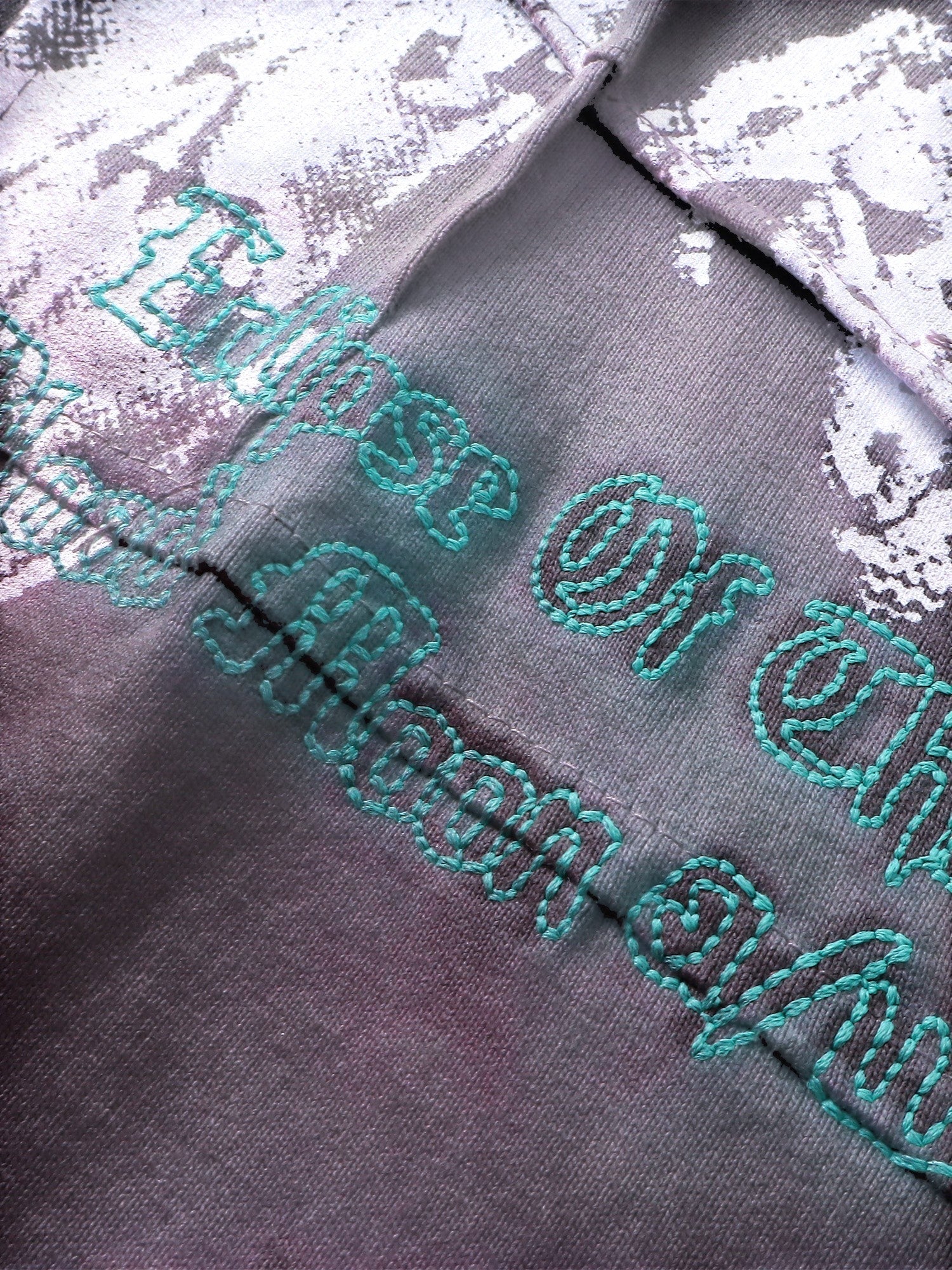 Close-up of the grey gradient spray wash on TBHNP black long-sleeve tee — men's streetwear detail