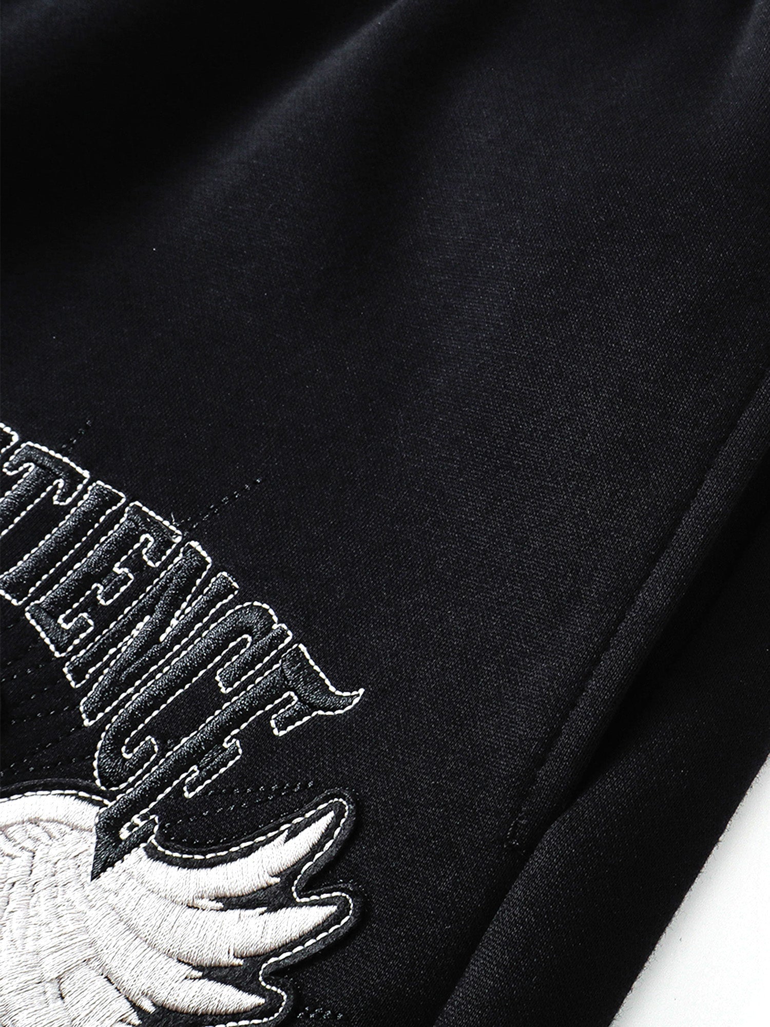 Raised eagle embroidery and tonal lettering texture close-up