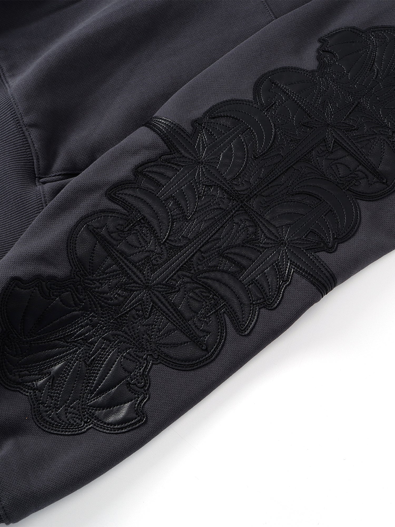 Close-up of the Black hoodie sleeve leather-patch embroidery.