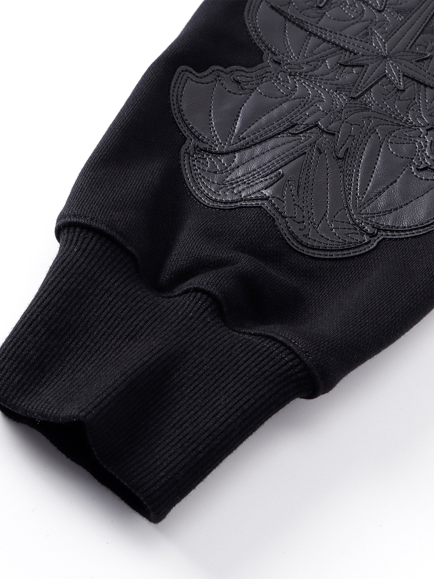 Close-up of the Grey Blue hoodie sleeve leather-patch embroidery.