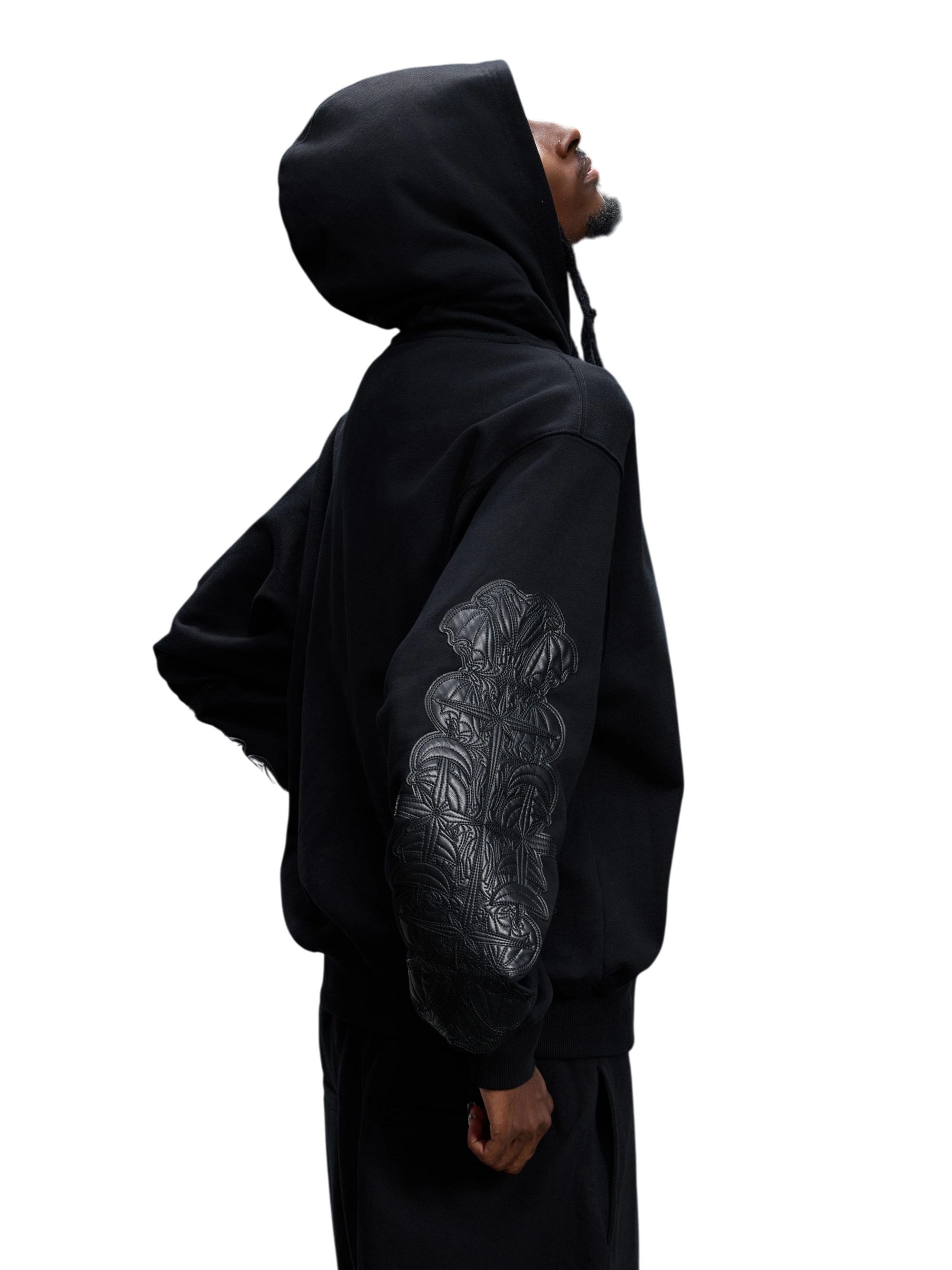 Model wearing the black Leather Patch Zip Hoodie, side view.