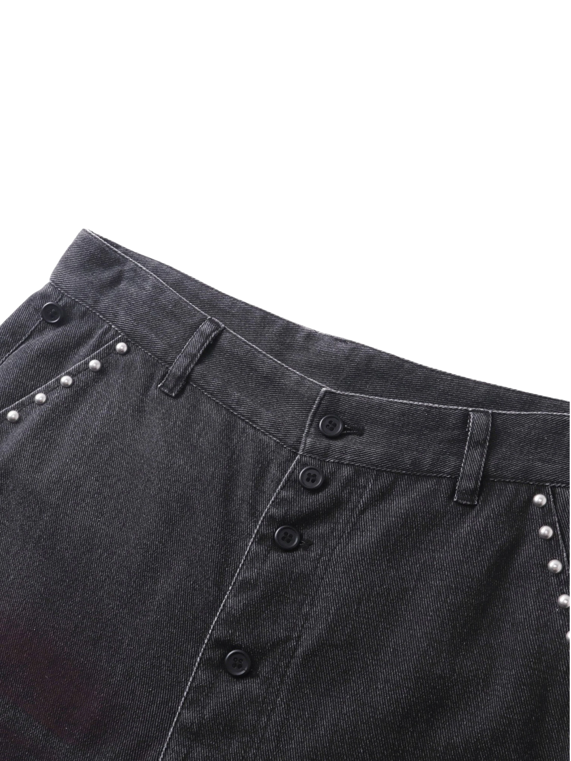 Close-up of the studded back pockets on TBHNP black spray-washed trousers — men's streetwear detail
