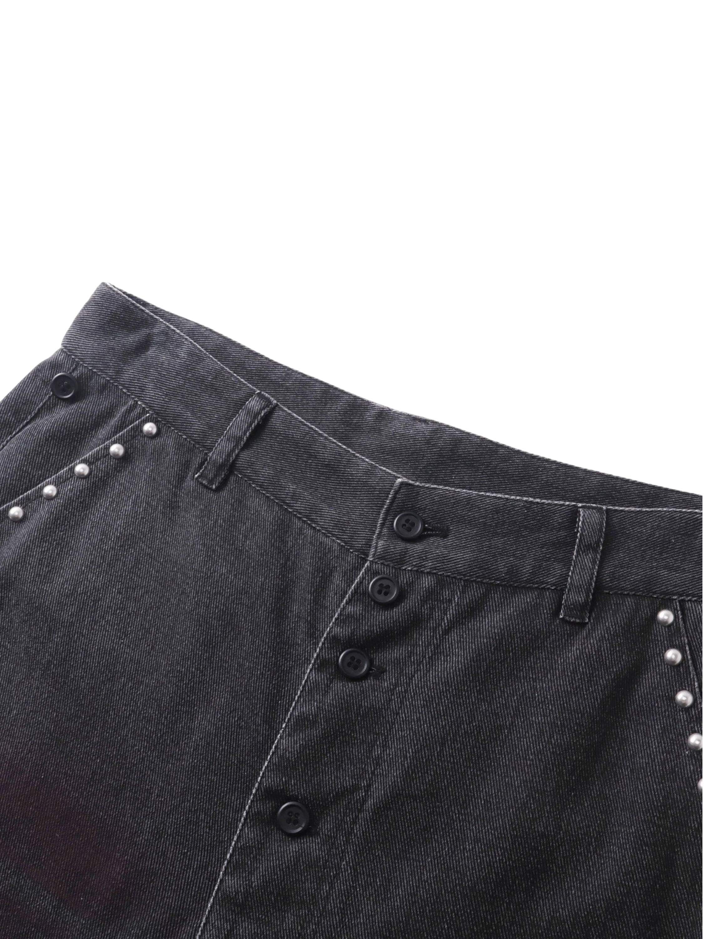 Close-up of the studded back pockets on TBHNP black spray-washed trousers — men's streetwear detail