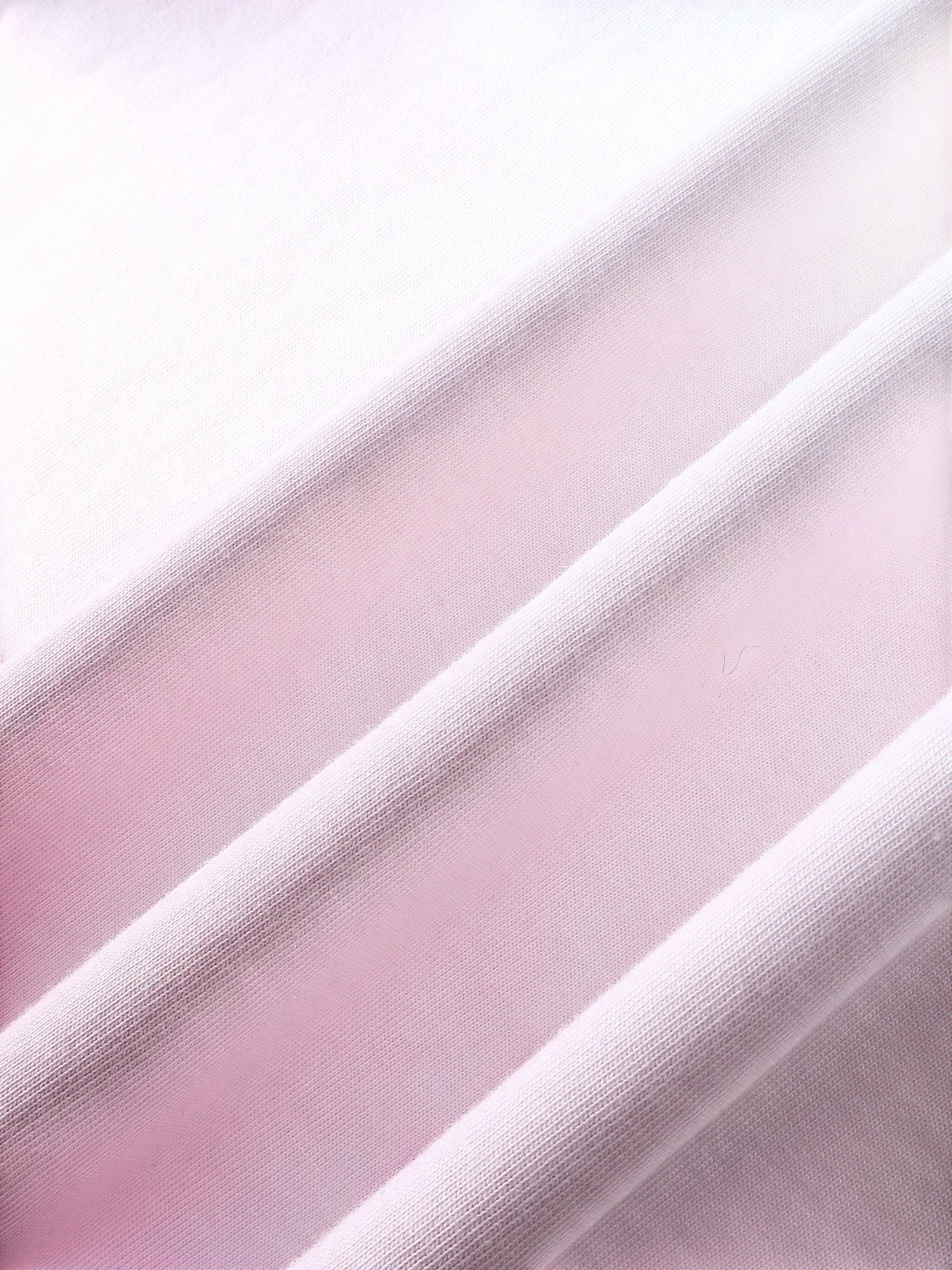 Close-up of the pink dip-dye wash on TBHNP white arrival short-sleeve tee — men's streetwear detail