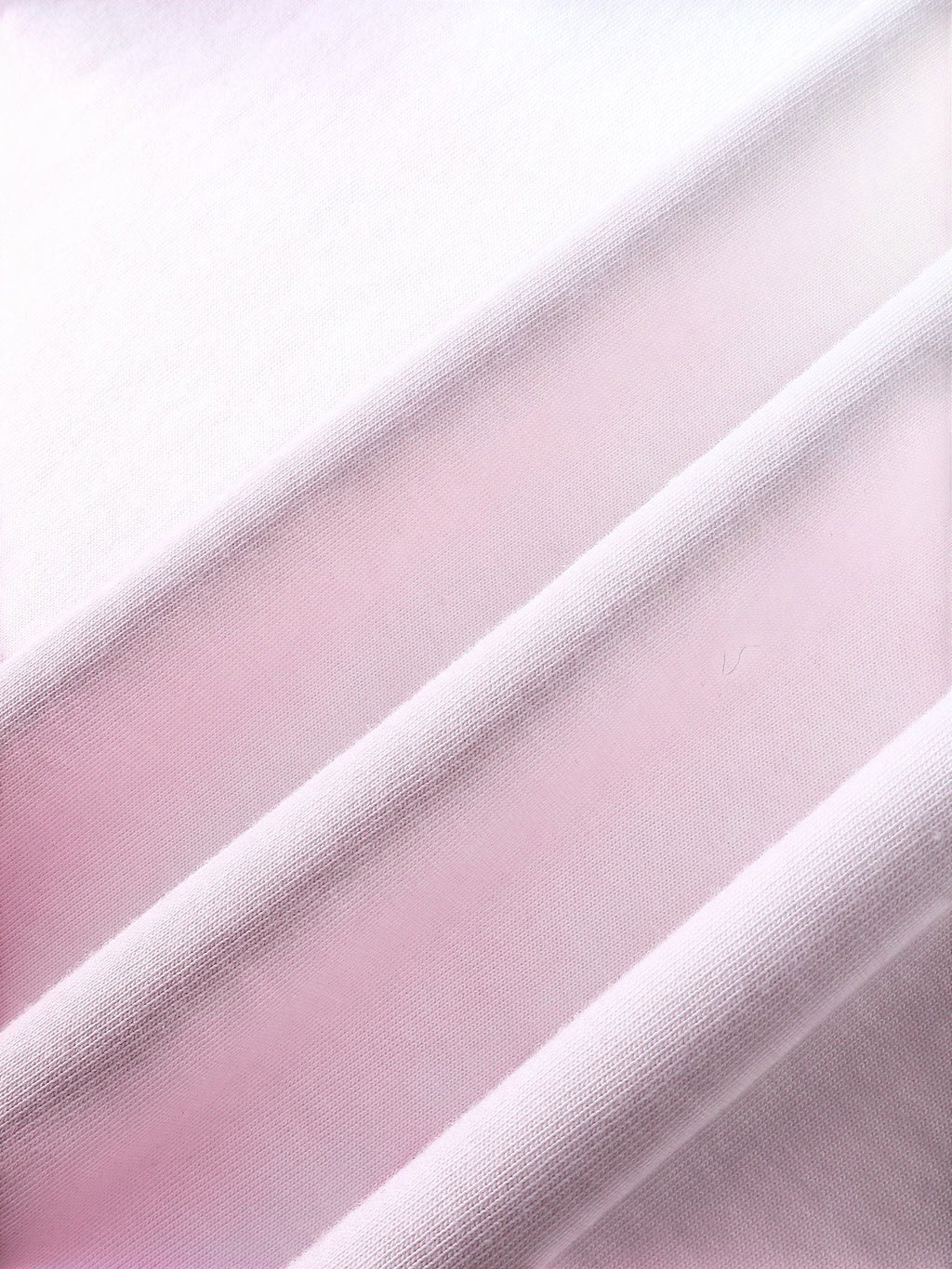 Close-up of the pink dip-dye wash on TBHNP white arrival short-sleeve tee — men's streetwear detail