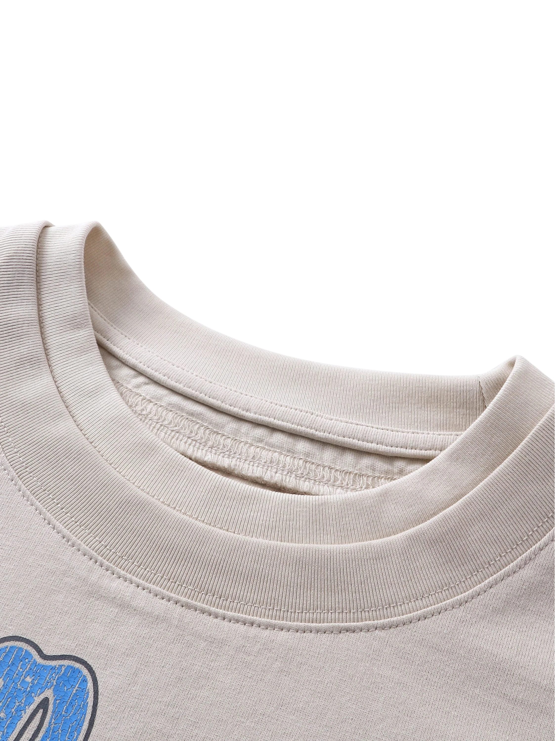 Close-up of the red triangle logo patch on TBHNP grayish-yellow knight tee — men's streetwear detail