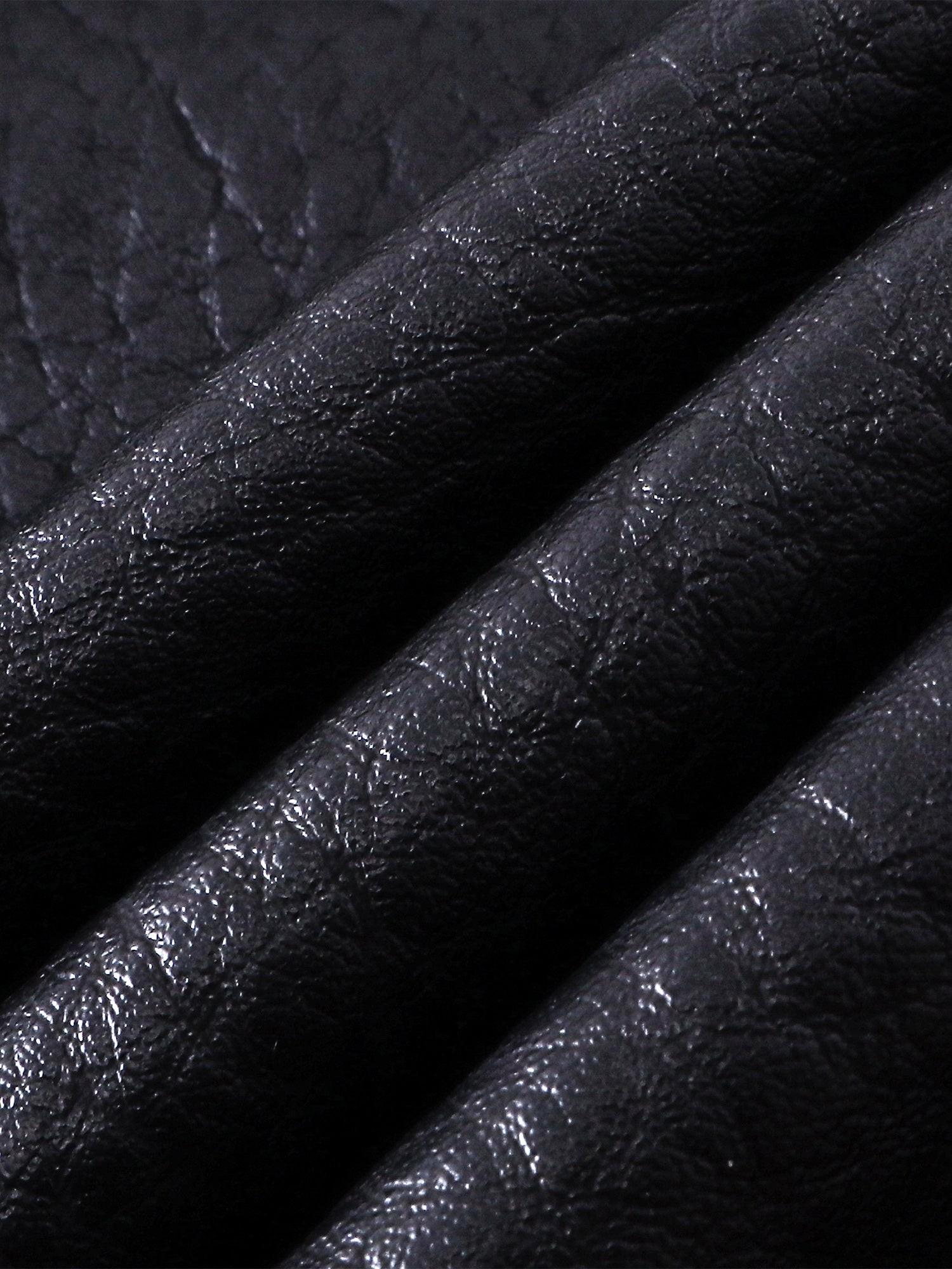 Close-up of the faux-leather texture on TBHNP Luminous Dawn shorts — men's streetwear detail