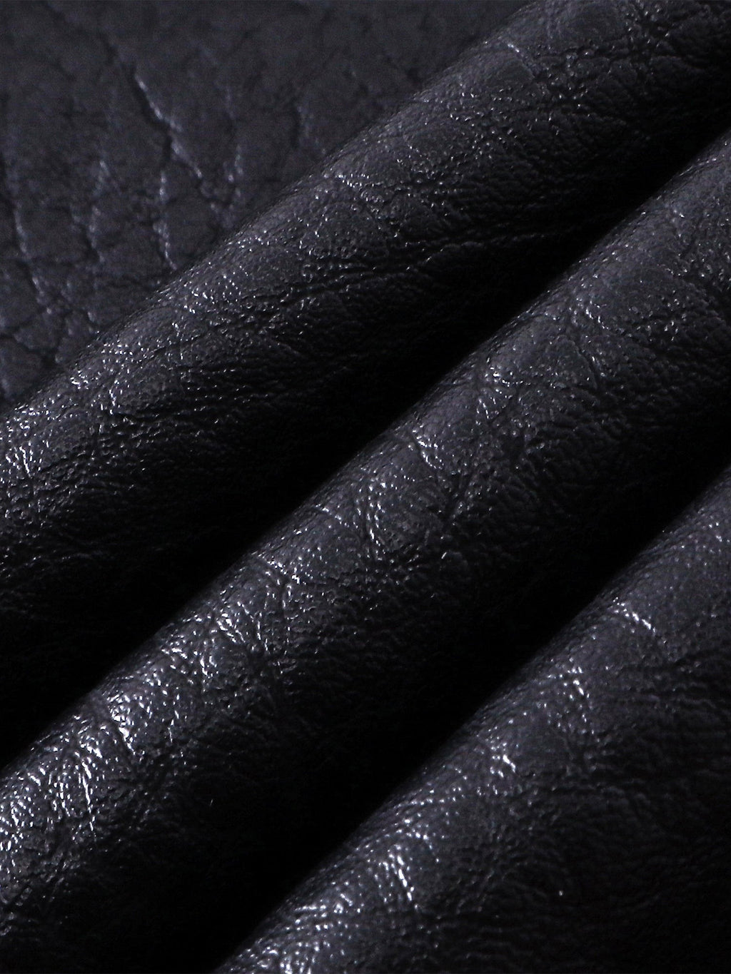 Close-up of the faux-leather texture on TBHNP Luminous Dawn shorts — men's streetwear detail