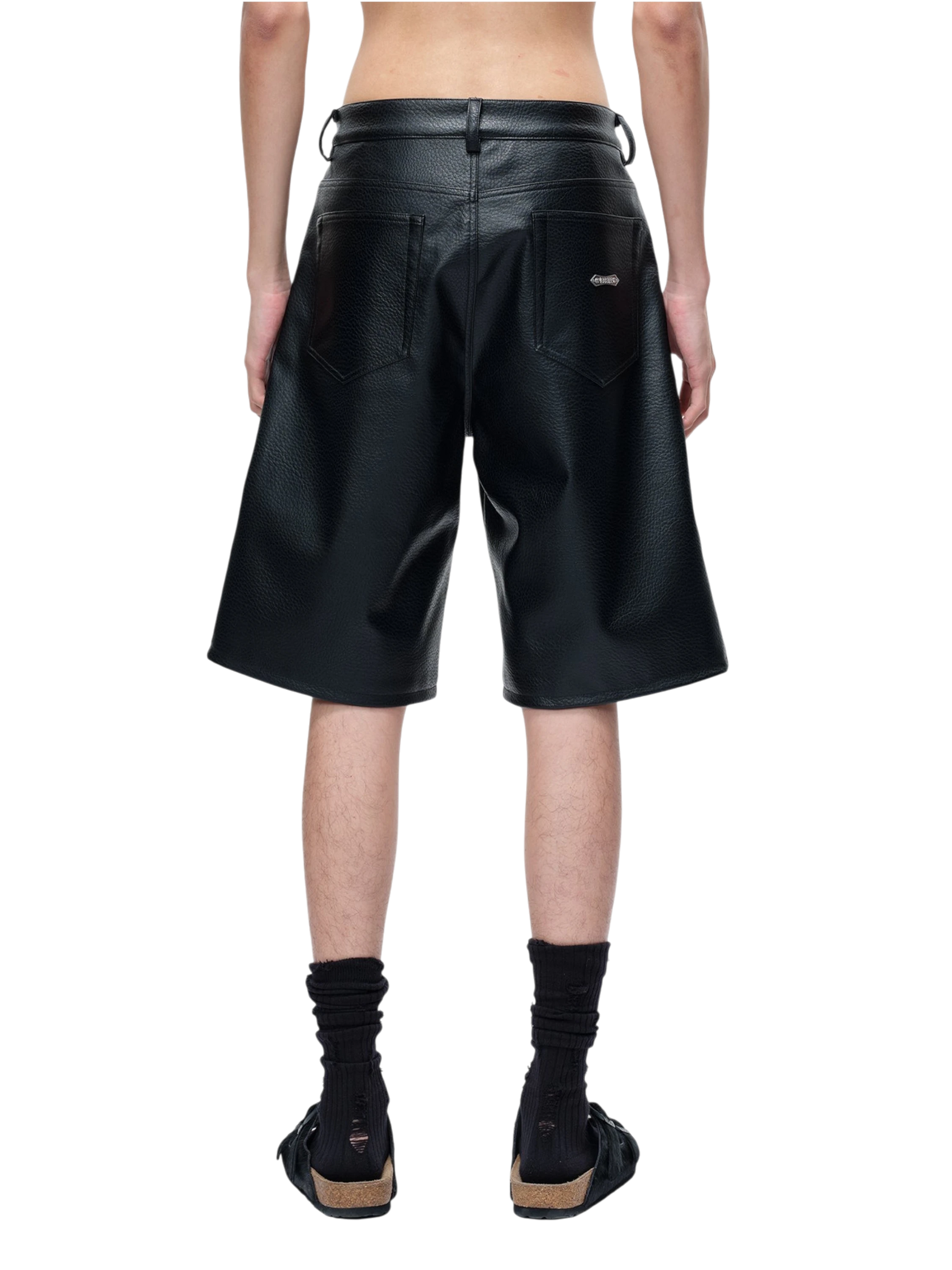 Model wearing TBHNP black faux-leather shorts, side view — men's streetwear shorts