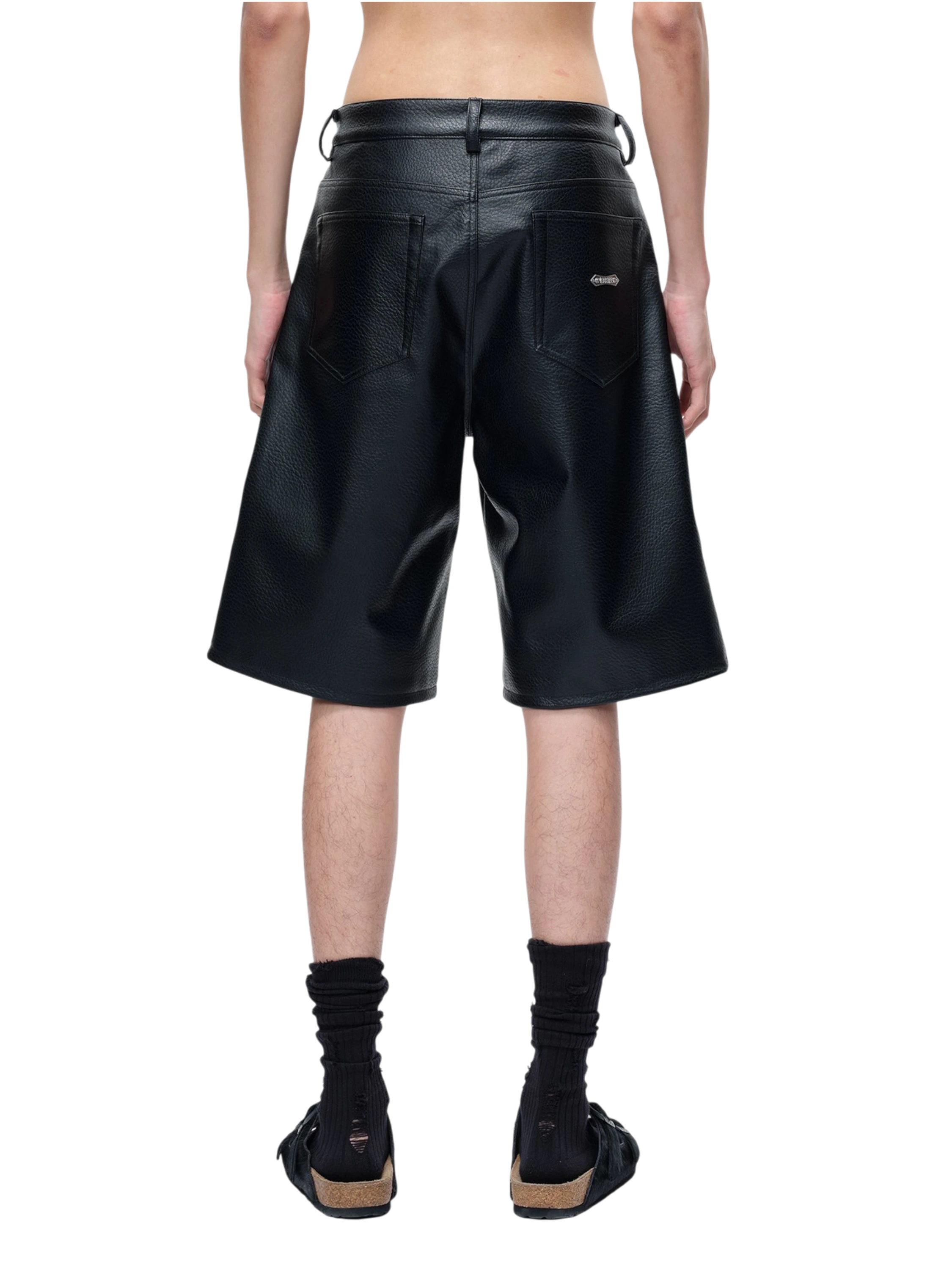 Model wearing TBHNP black faux-leather shorts, side view — men's streetwear shorts