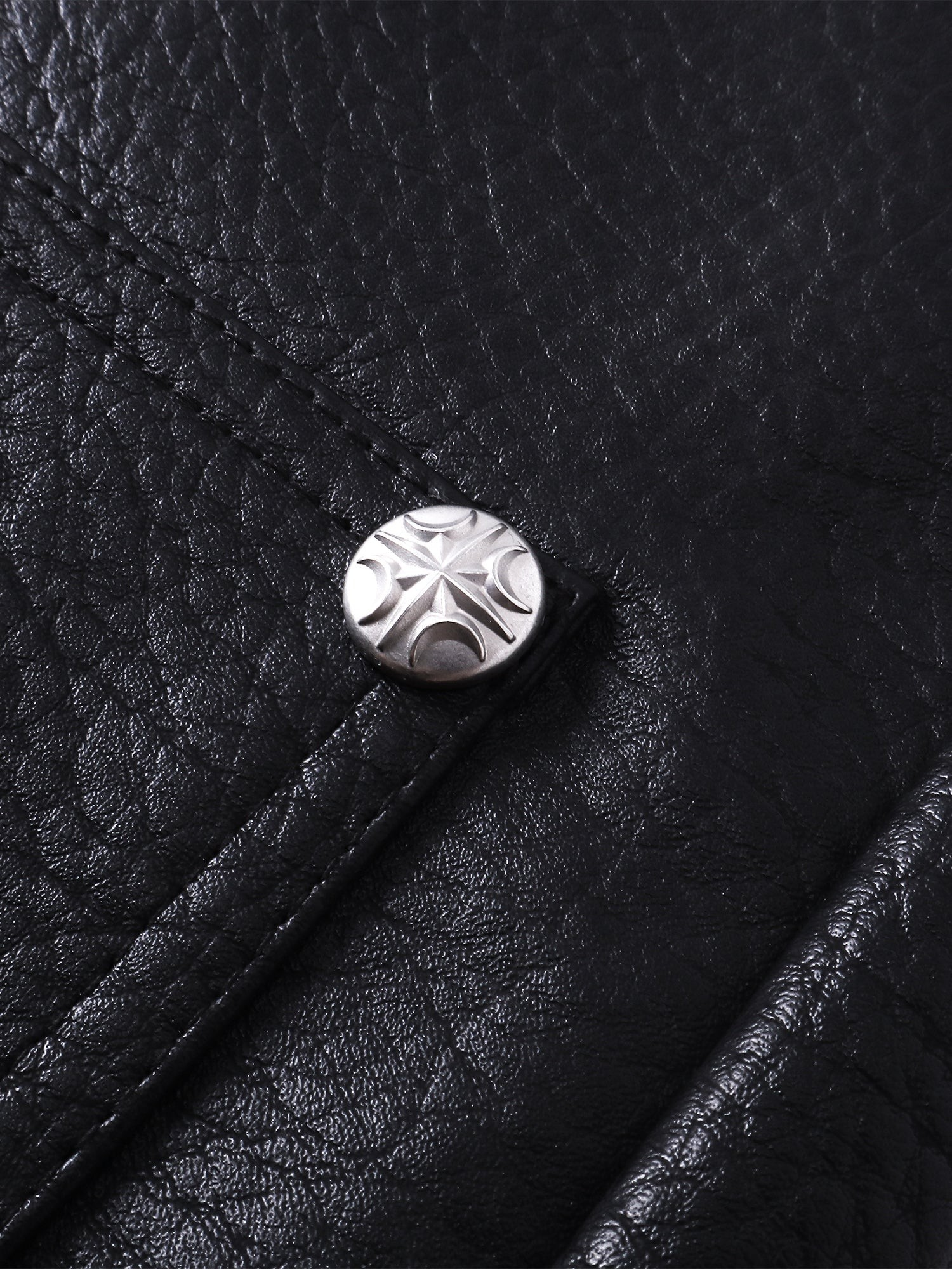 Close-up of the metal button on TBHNP black faux-leather shorts — men's streetwear detail