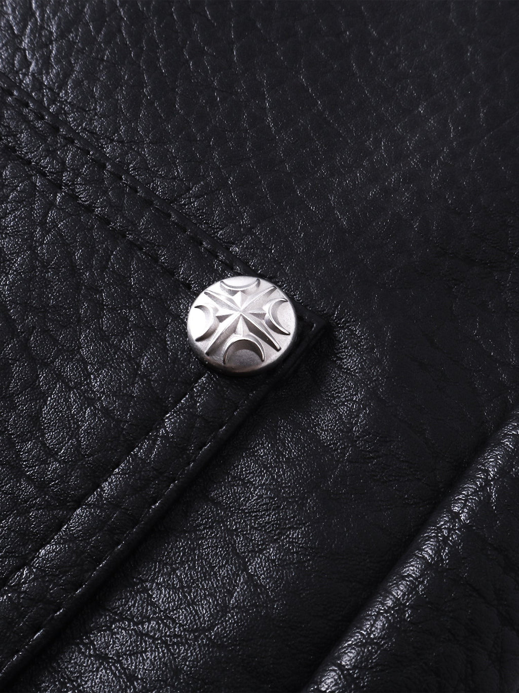 Close-up of the metal button on TBHNP black faux-leather shorts — men's streetwear detail