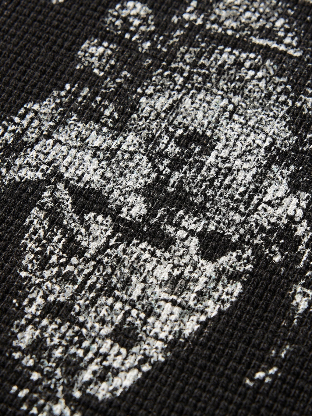 Close-up of the sword-and-bone print on TBHNP black waffle-knit tee — men's streetwear detail