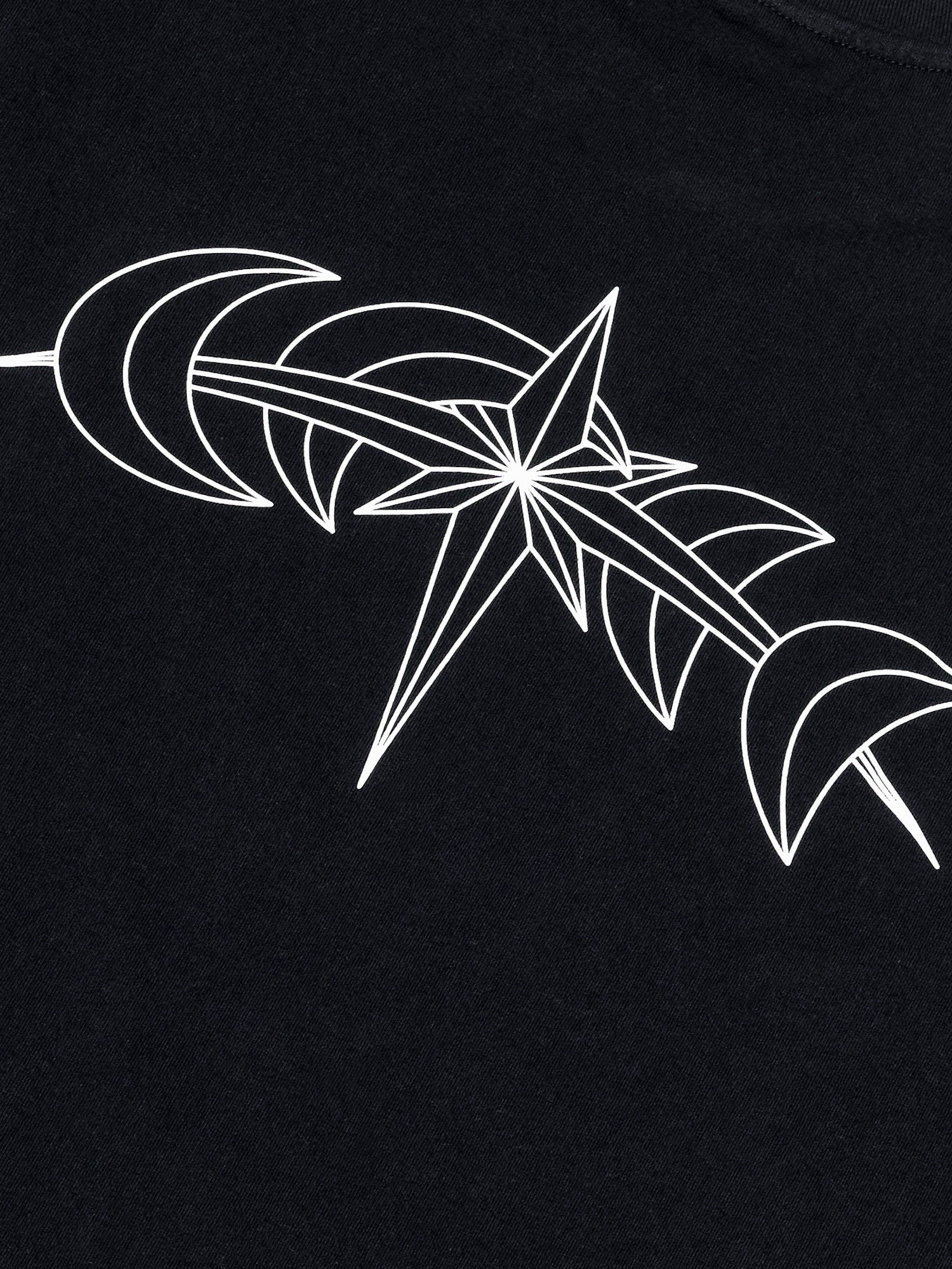 Detalle del estampado trasero blanco con estrella astral y medias lunas sobre algodón negro