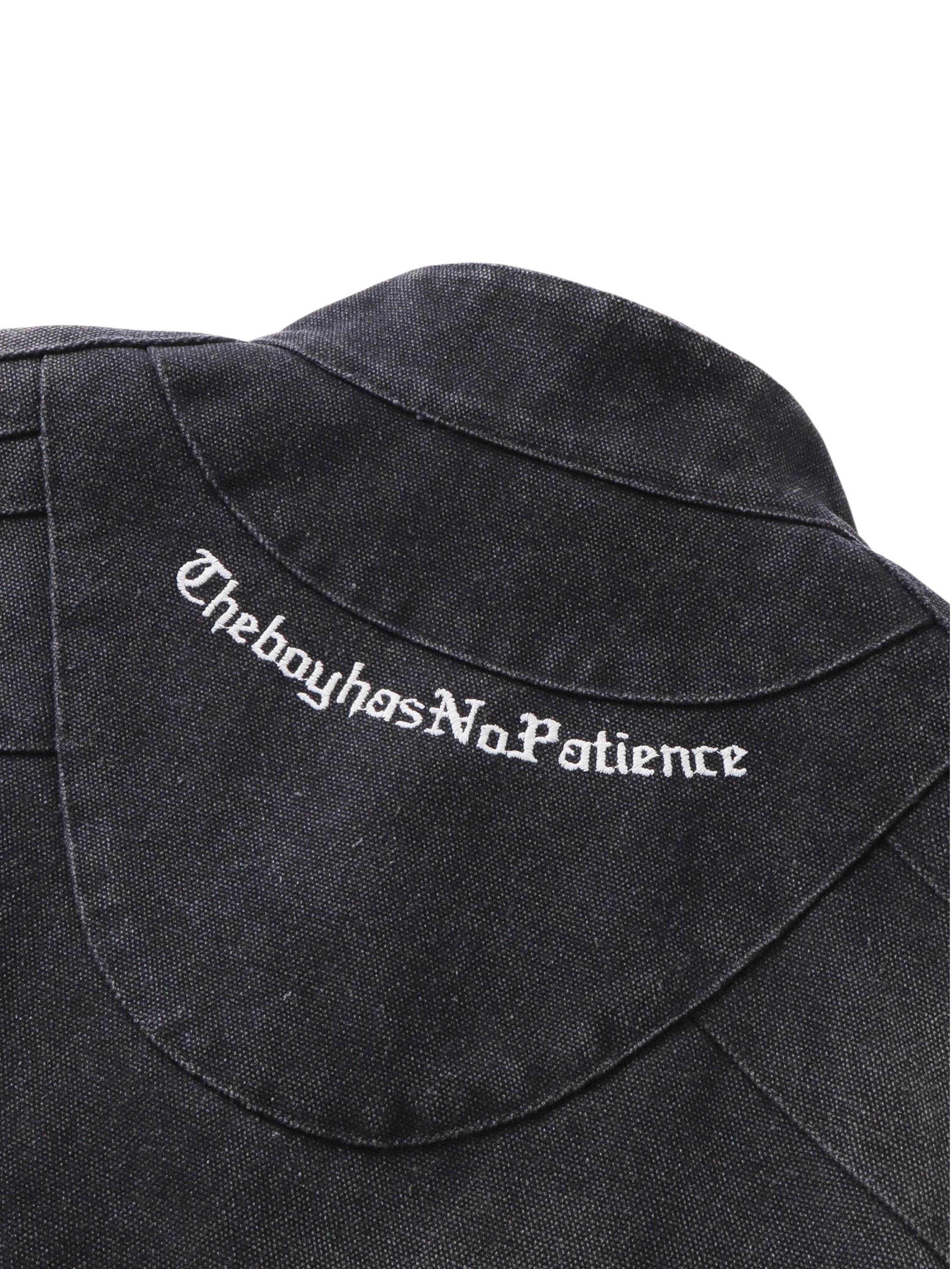 Close-up of TheBoyHasNoPatience embroidered branding on the canvas moto jacket — men's streetwear detail