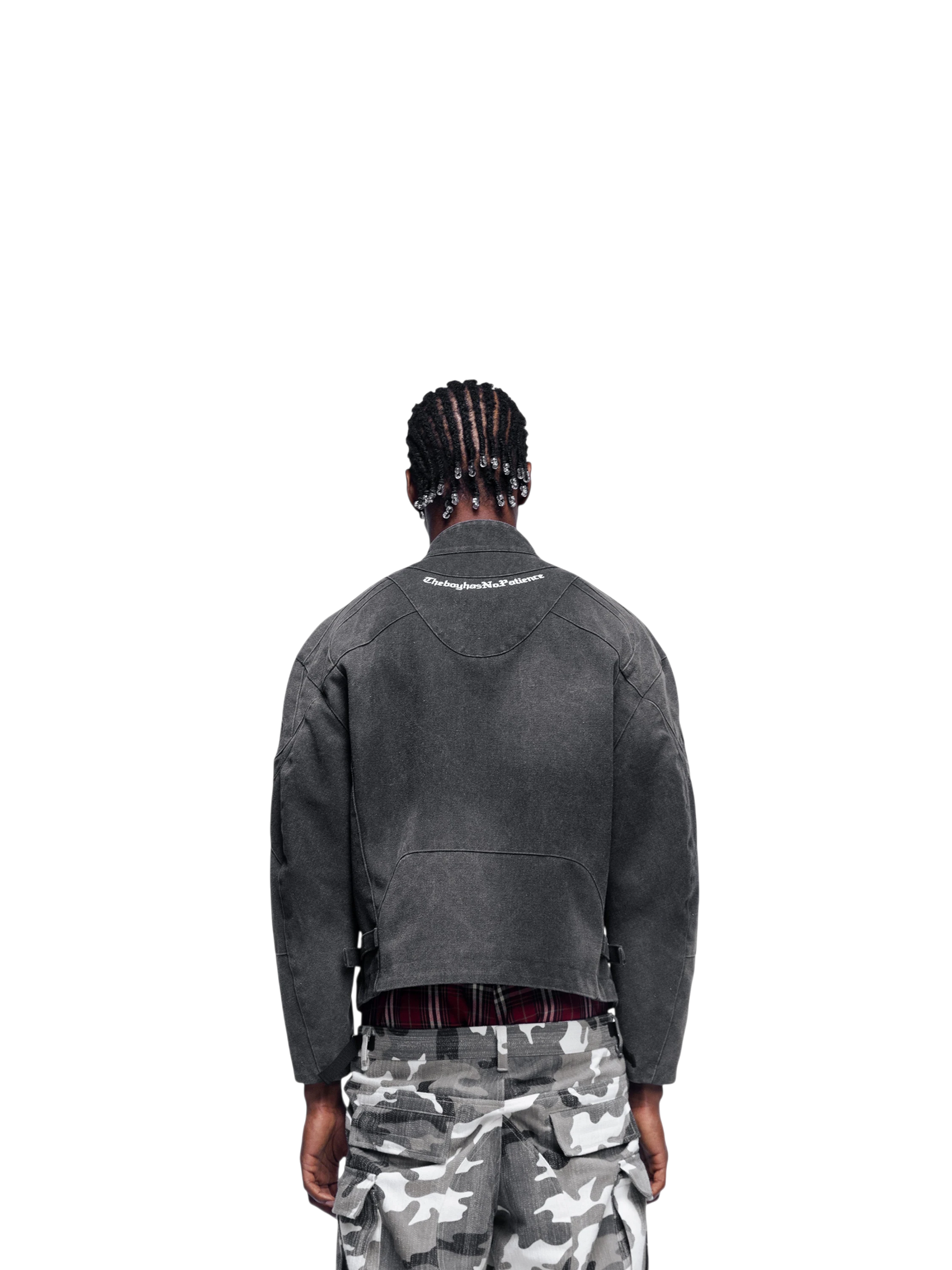 Male model wearing TBHNP black canvas moto jacket, back view — men's streetwear jacket