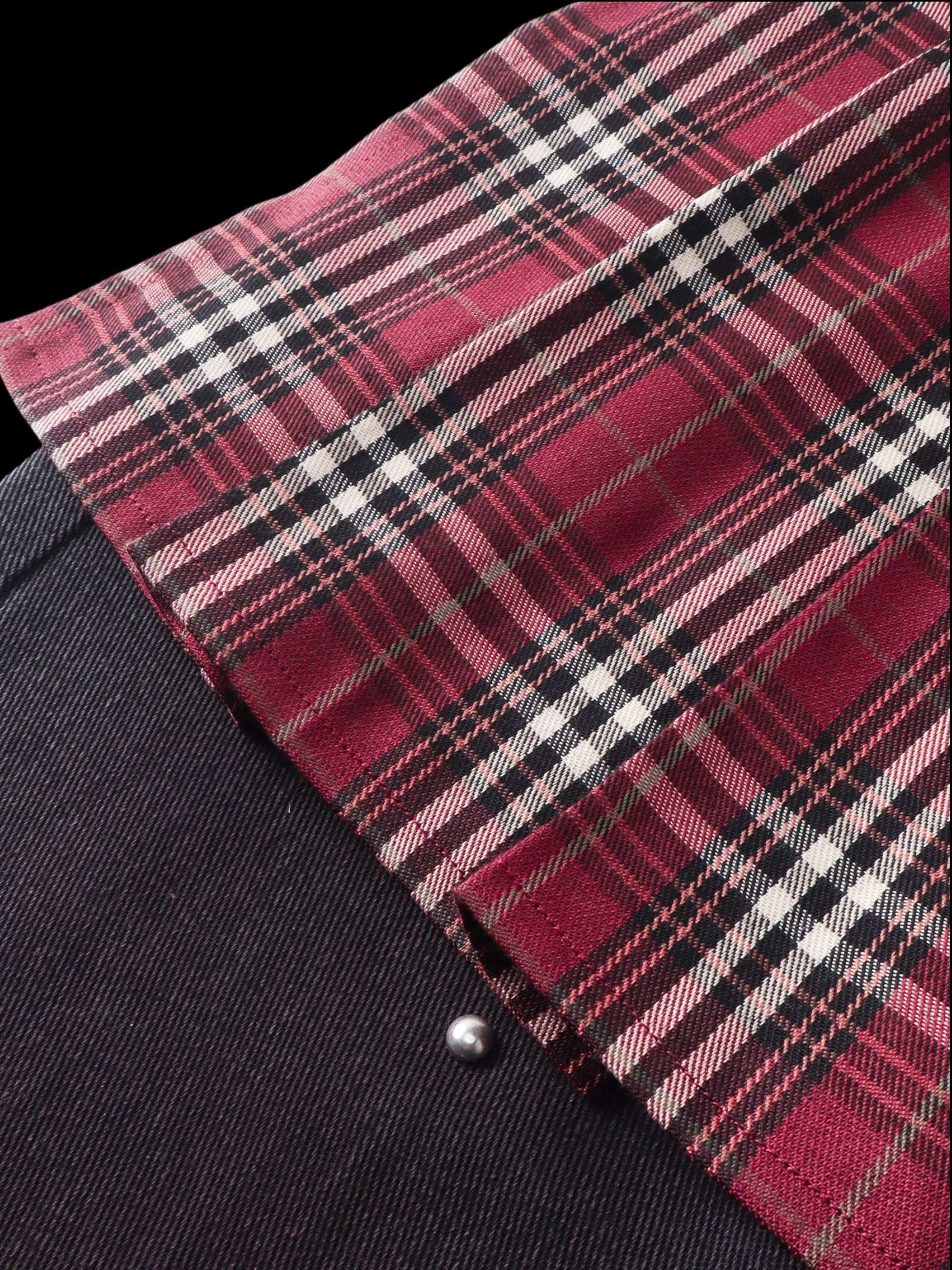 Close-up of the burgundy plaid mini-skirt fabric and raw edge on TBHNP trousers — men's streetwear detail