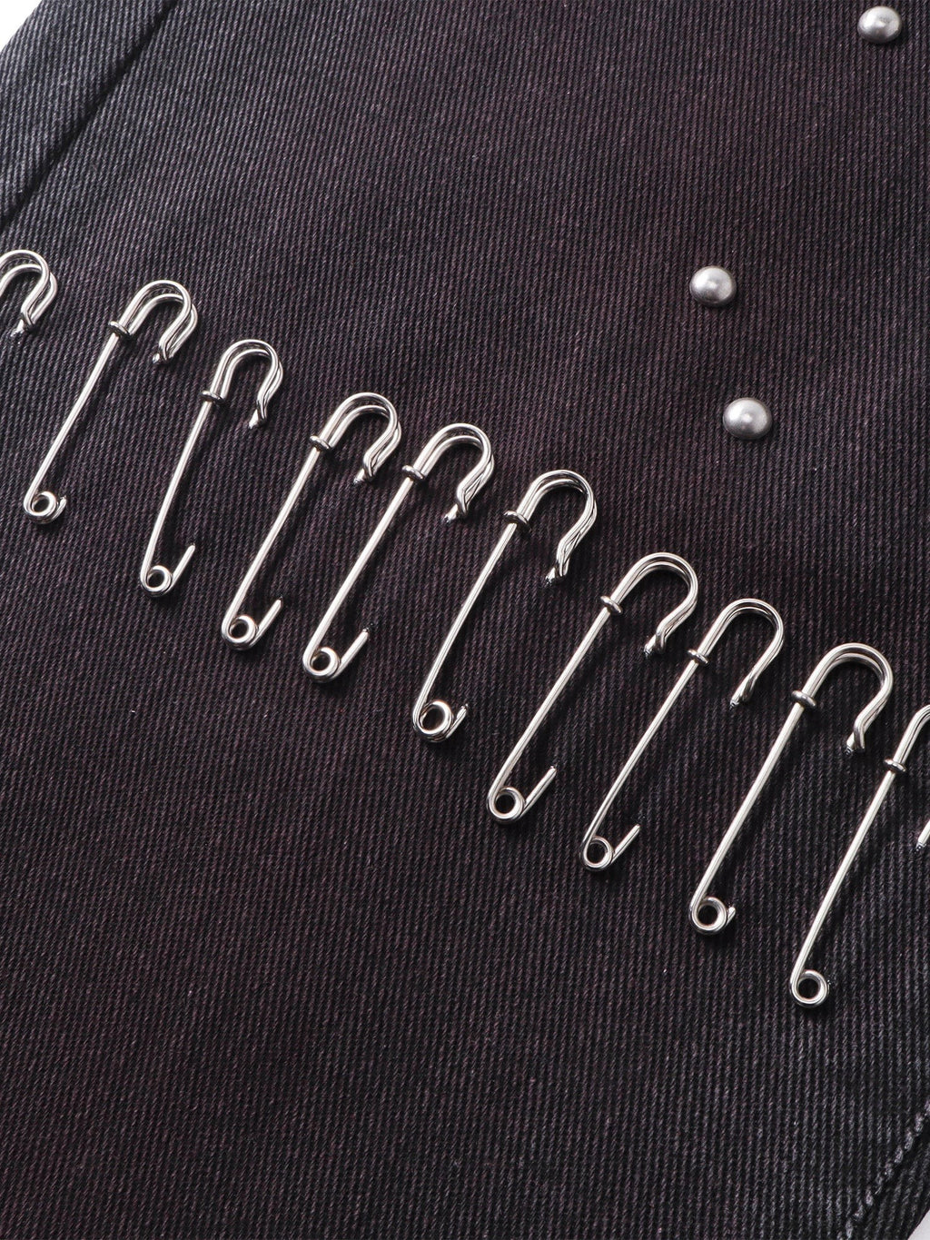 Close-up of the safety-pin detailing on TBHNP spray-washed trousers — men's streetwear detail