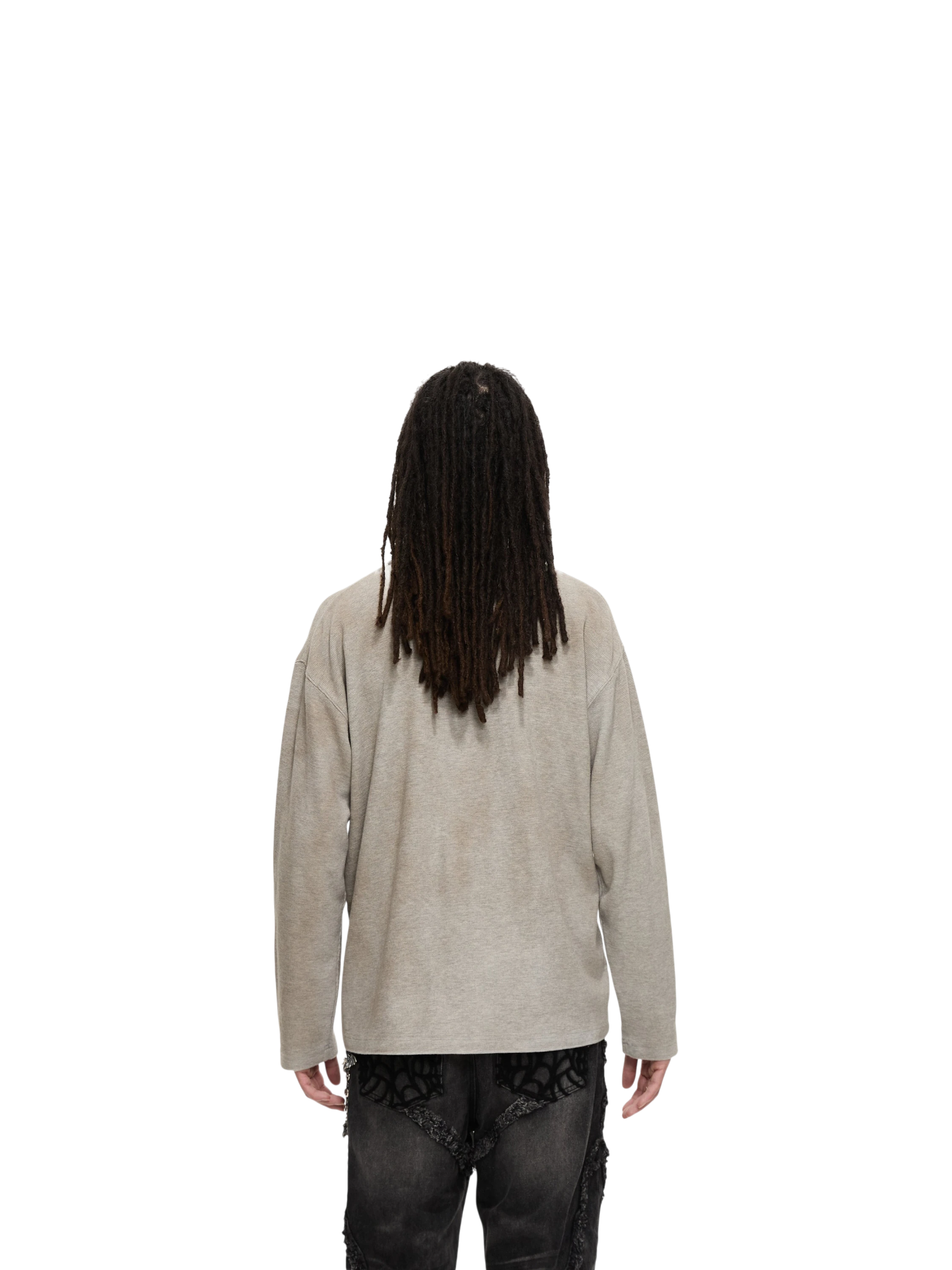 Model in TBHNP grey sword-and-bone henley long-sleeve tee, side angle — men's streetwear tee