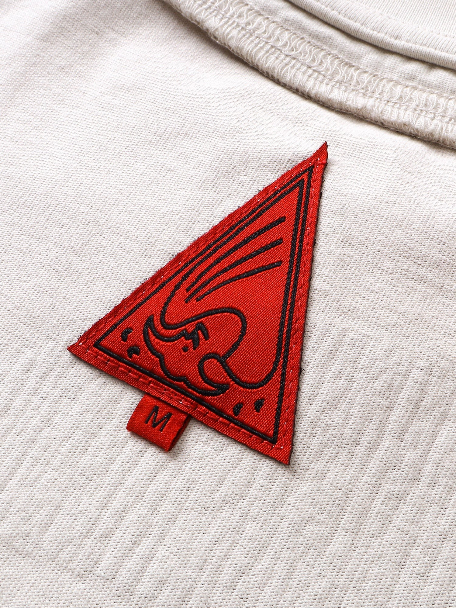Close-up of the crescent-moon print on TBHNP grayish-yellow knight tee — men's streetwear detail
