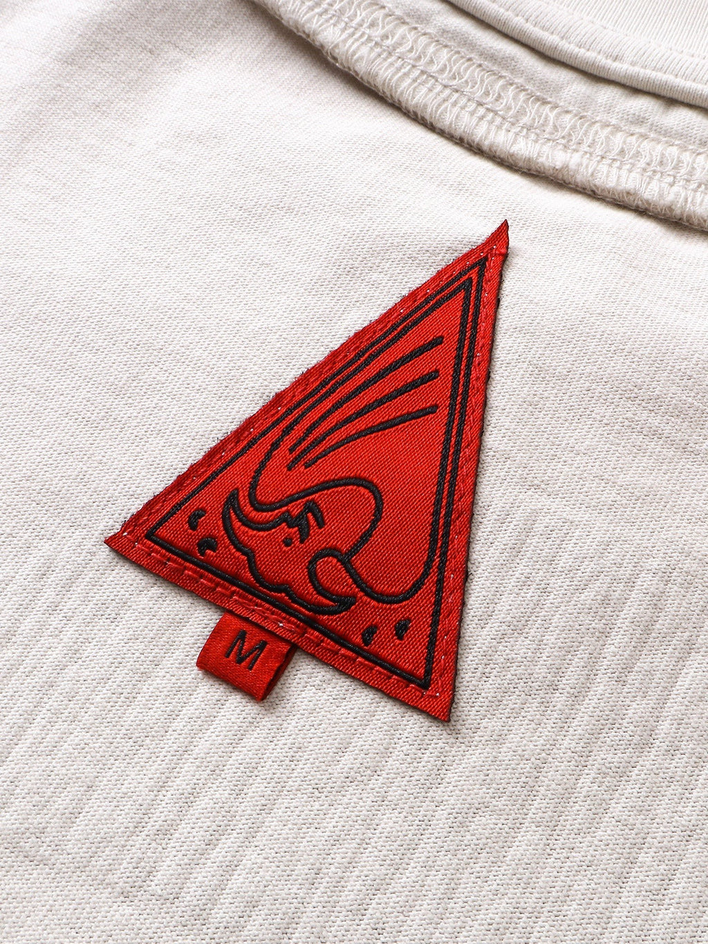 Close-up of the crescent-moon print on TBHNP grayish-yellow knight tee — men's streetwear detail