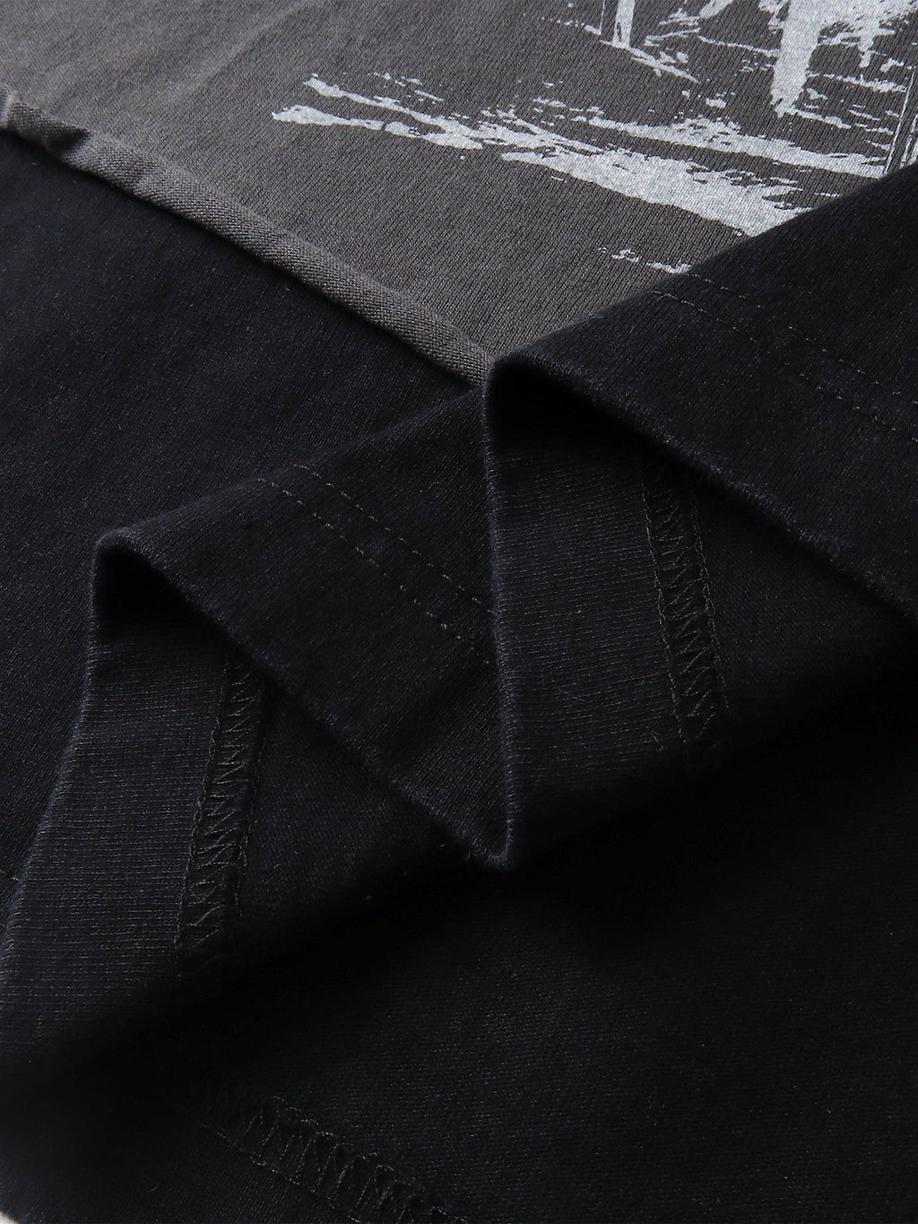 Close-up of the layered faux-two-piece hem on TBHNP black knight tee — men's streetwear detail