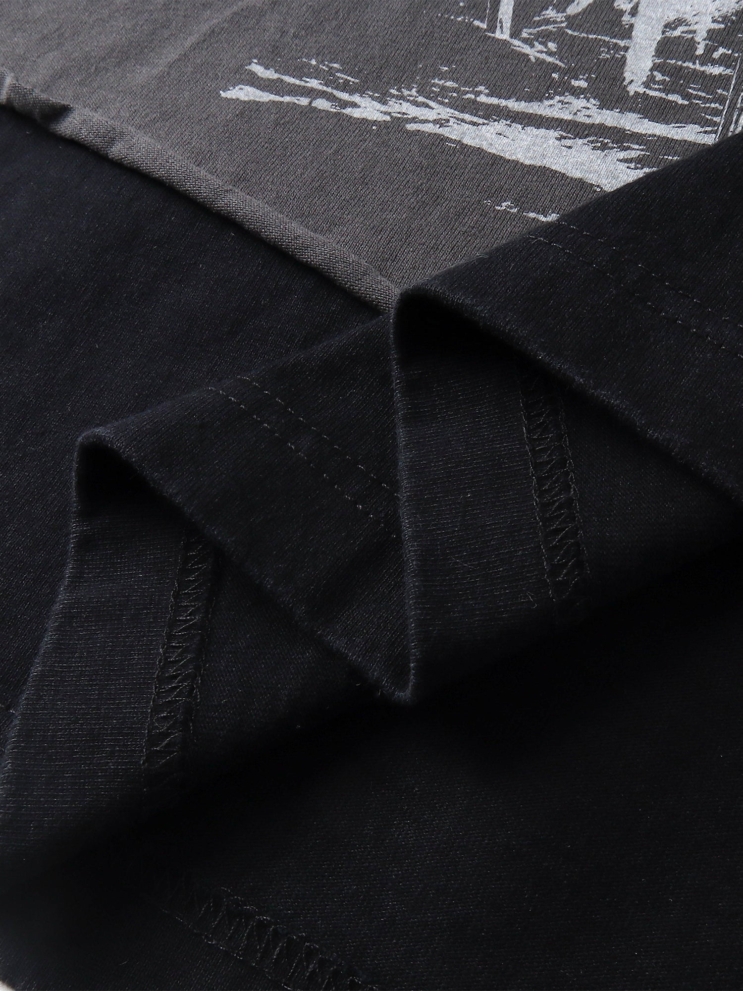 Close-up of the layered faux-two-piece hem on TBHNP black knight tee — men's streetwear detail