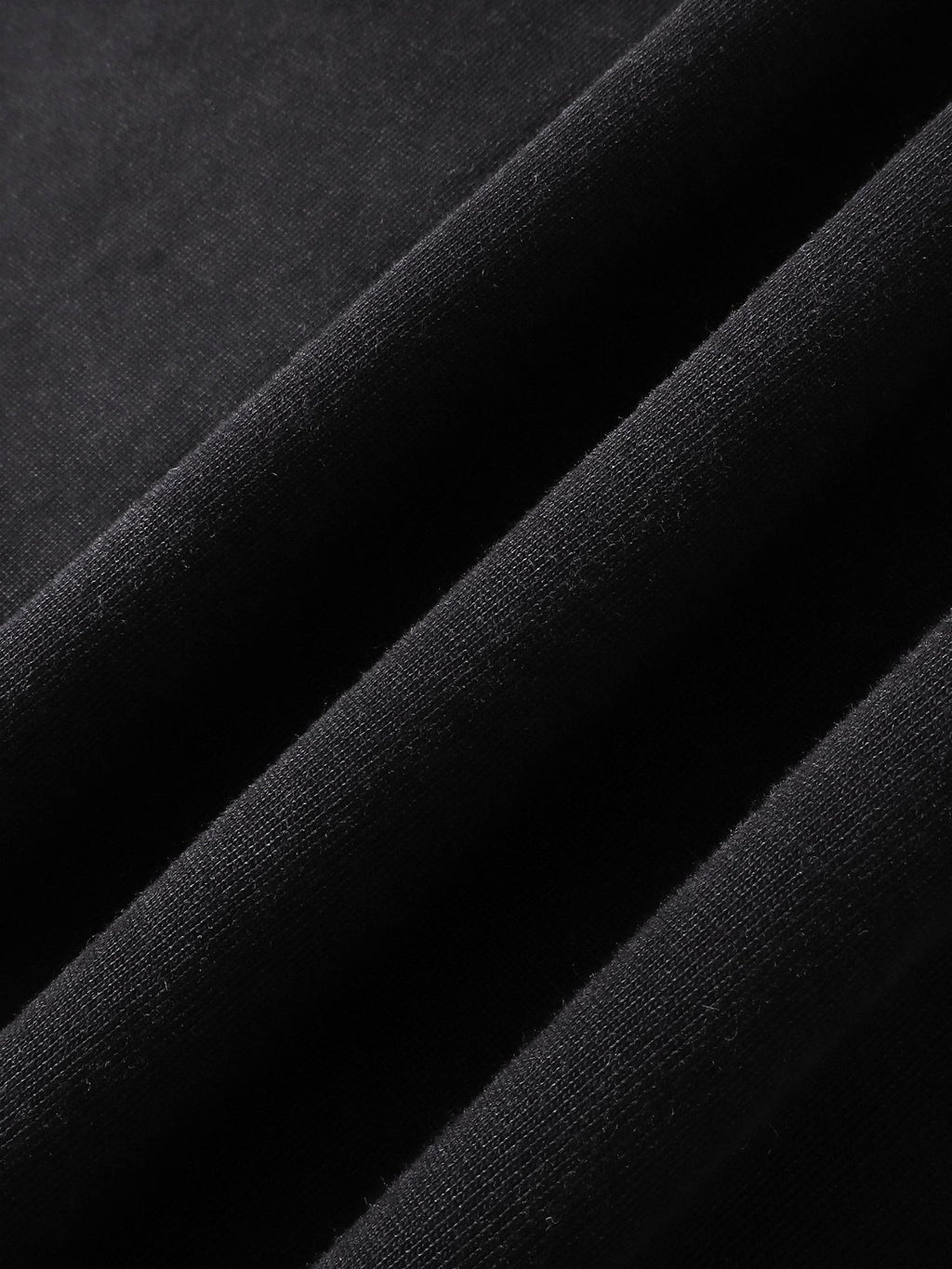 Close-up of the cotton fabric texture on TBHNP black arrival tee — men's streetwear detail