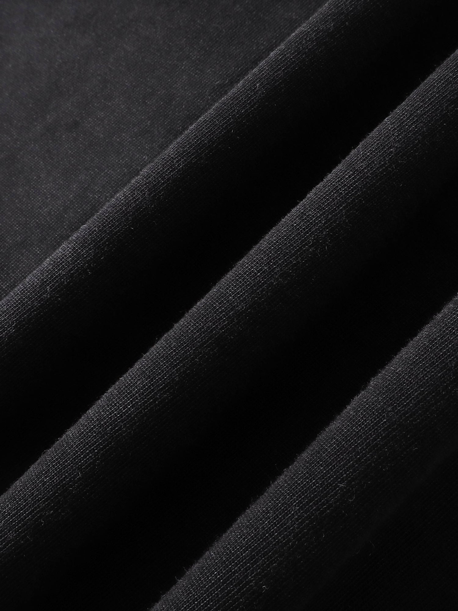 Close-up of the cotton fabric texture on TBHNP black arrival tee — men's streetwear detail