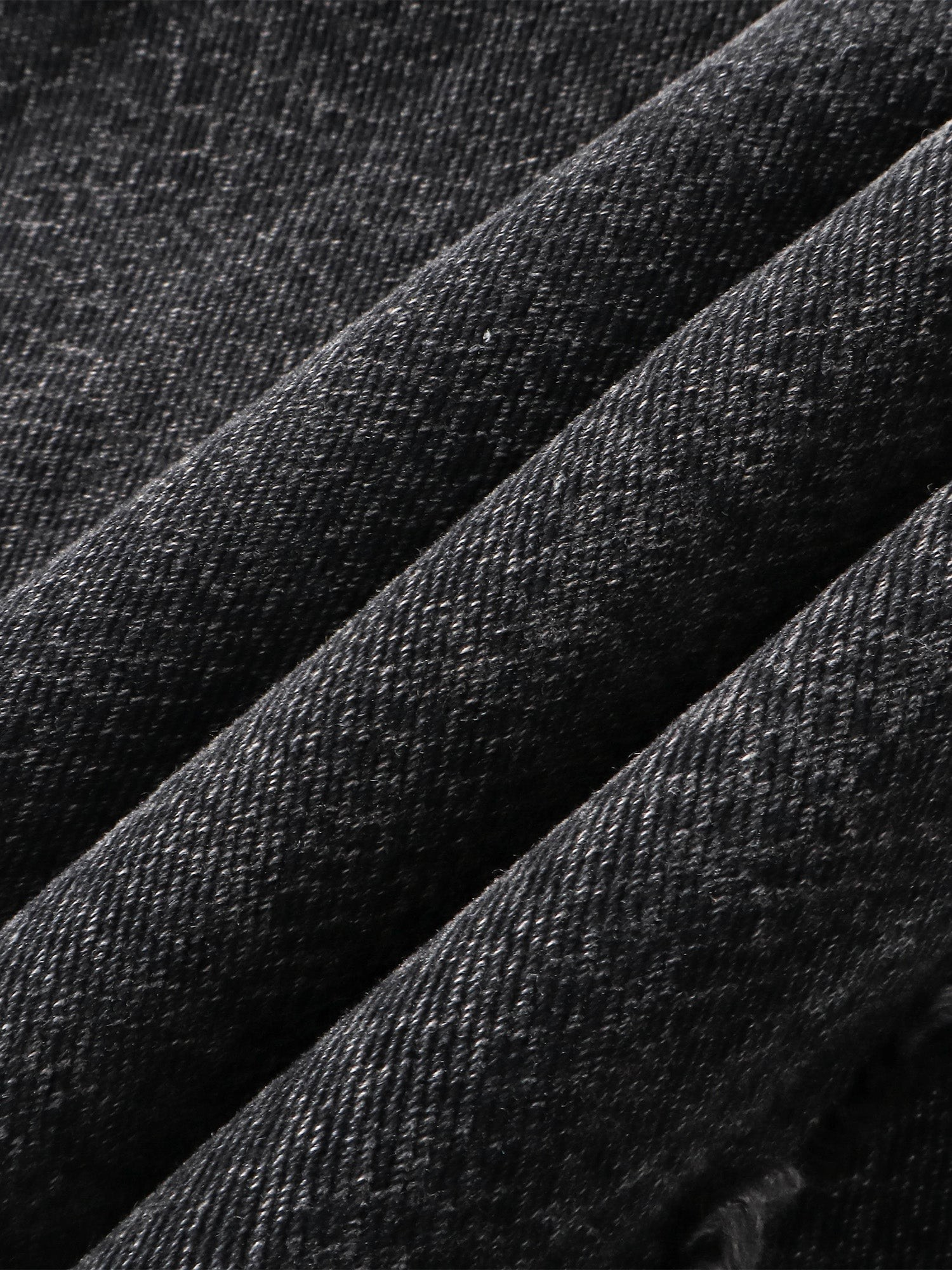 Close-up of the 3D snake-curve panel seam on TBHNP cobra print jeans — men's streetwear detail
