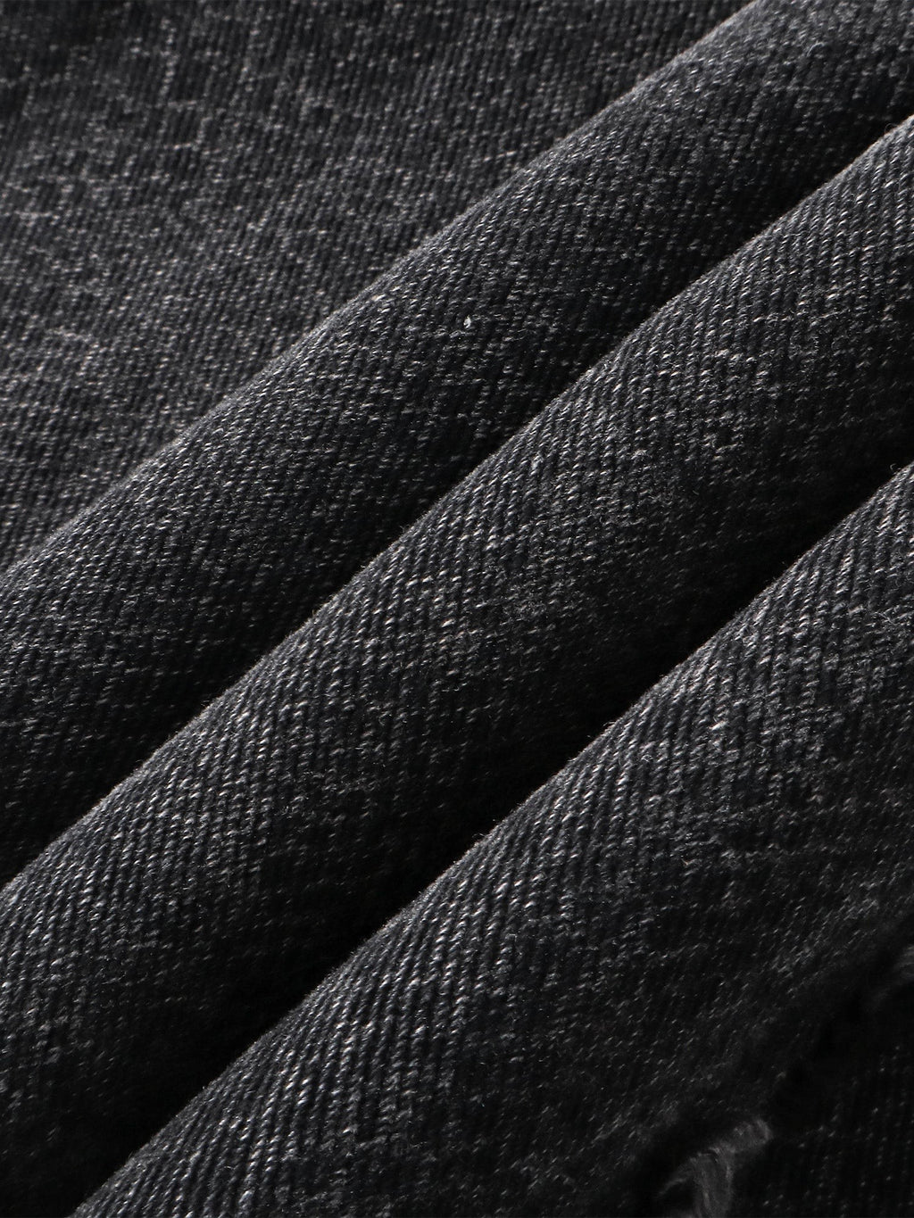 Close-up of the 3D snake-curve panel seam on TBHNP cobra print jeans — men's streetwear detail