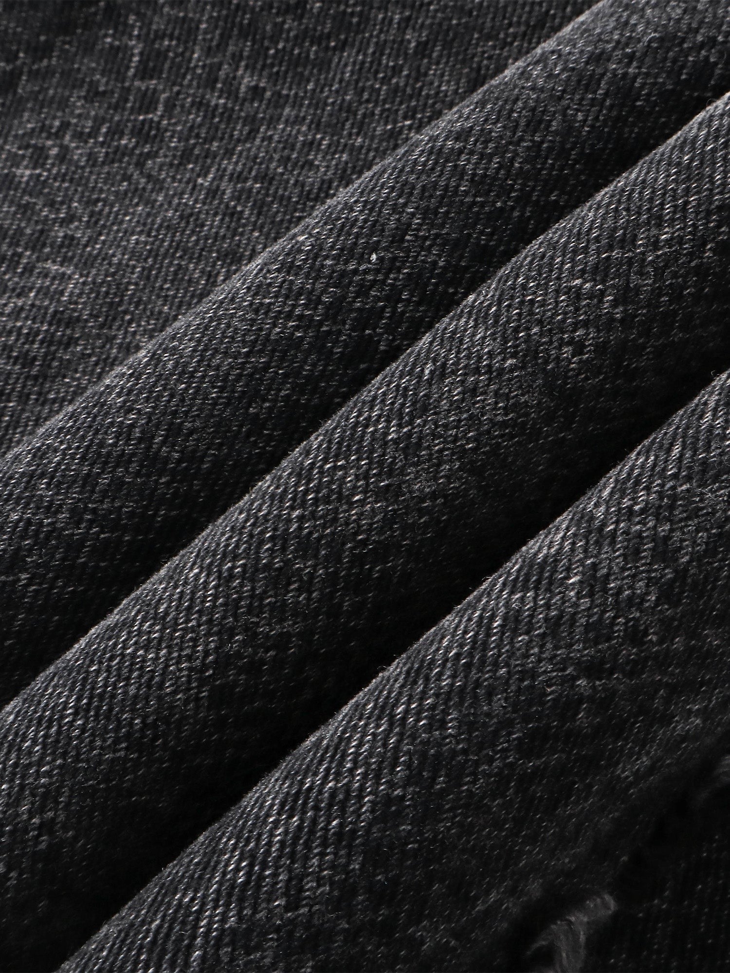 Close-up of the 3D snake-curve panel seam on TBHNP cobra print jeans — men's streetwear detail