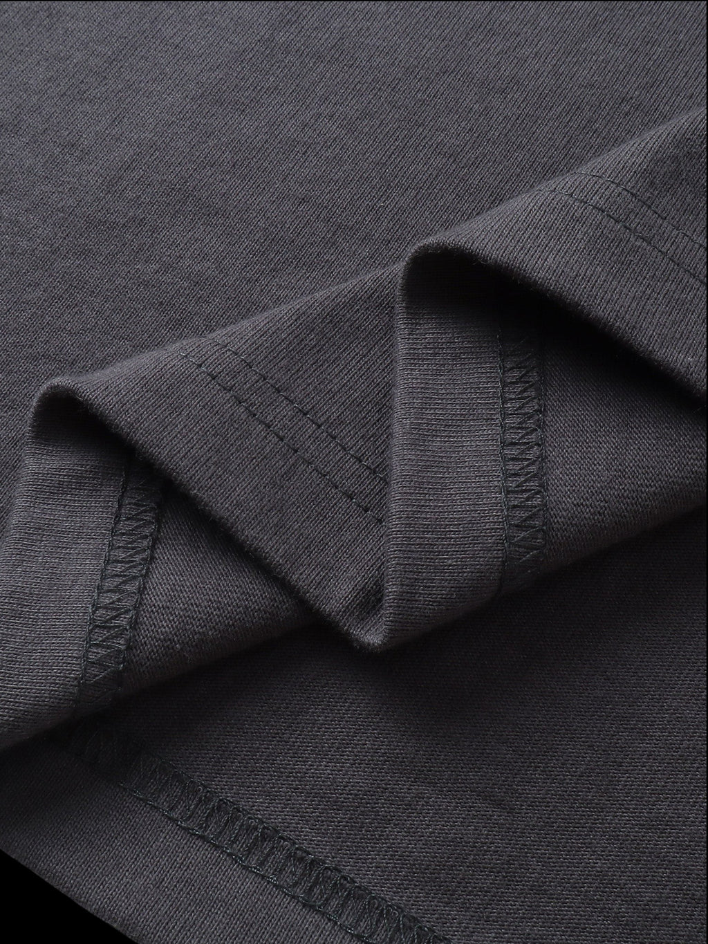 Close-up of the fabric fold on TBHNP dark grey Shadowbat vest — men's streetwear detail