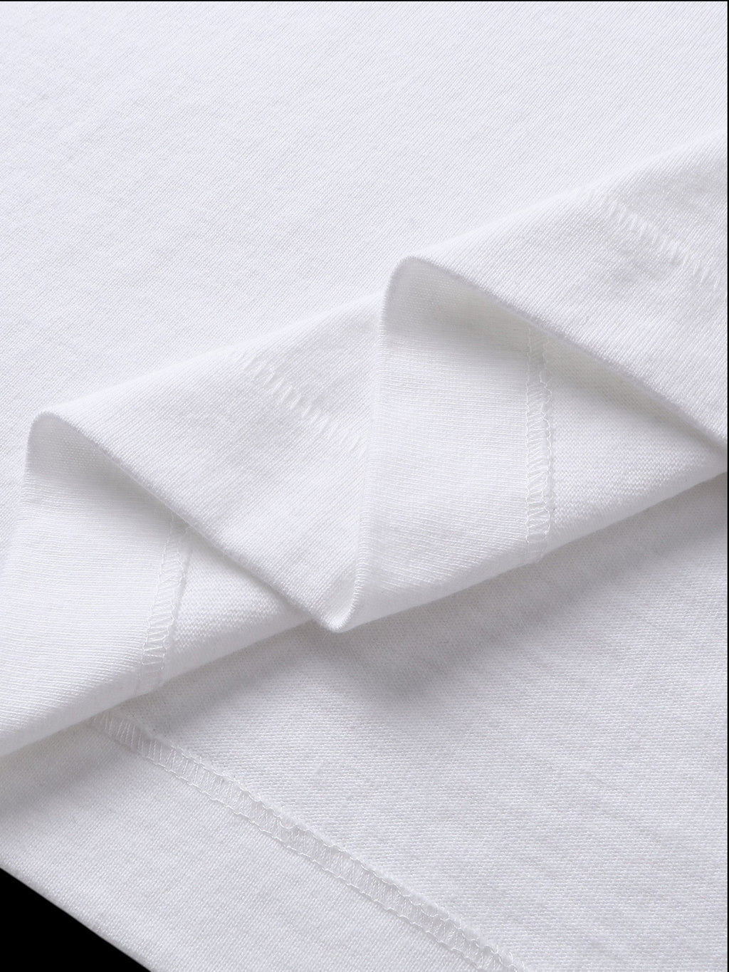 Close-up of the cotton texture on TBHNP white Emblem & Shadowbat tee — men's streetwear detail