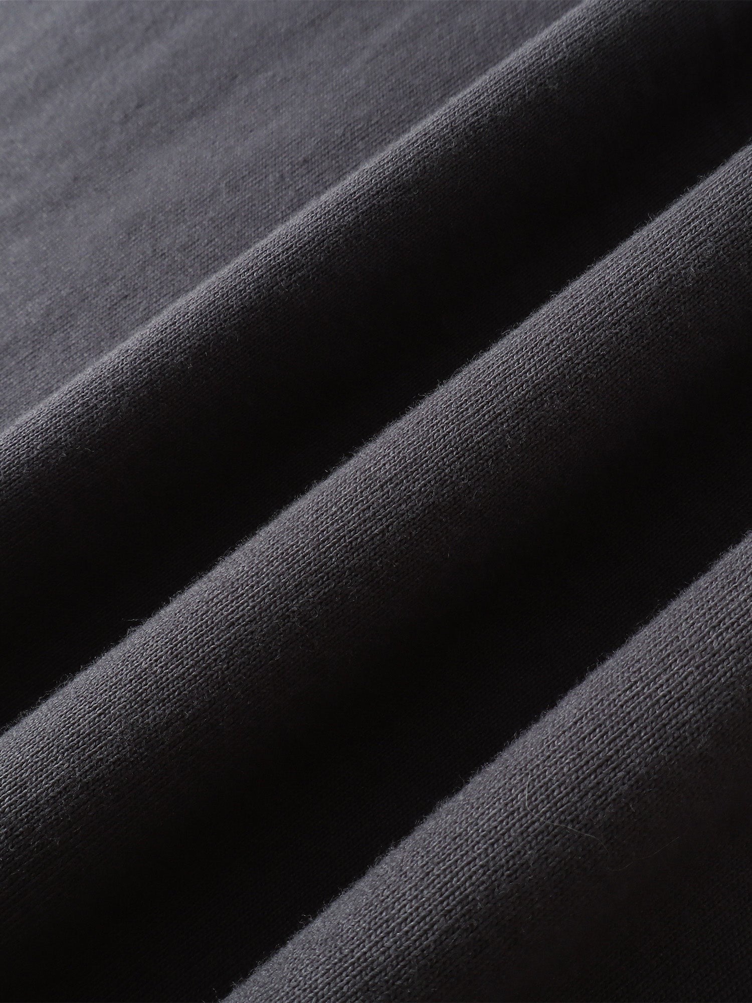 Close-up of the cotton texture on TBHNP dark grey Emblem & Shadowbat tee — men's streetwear detail