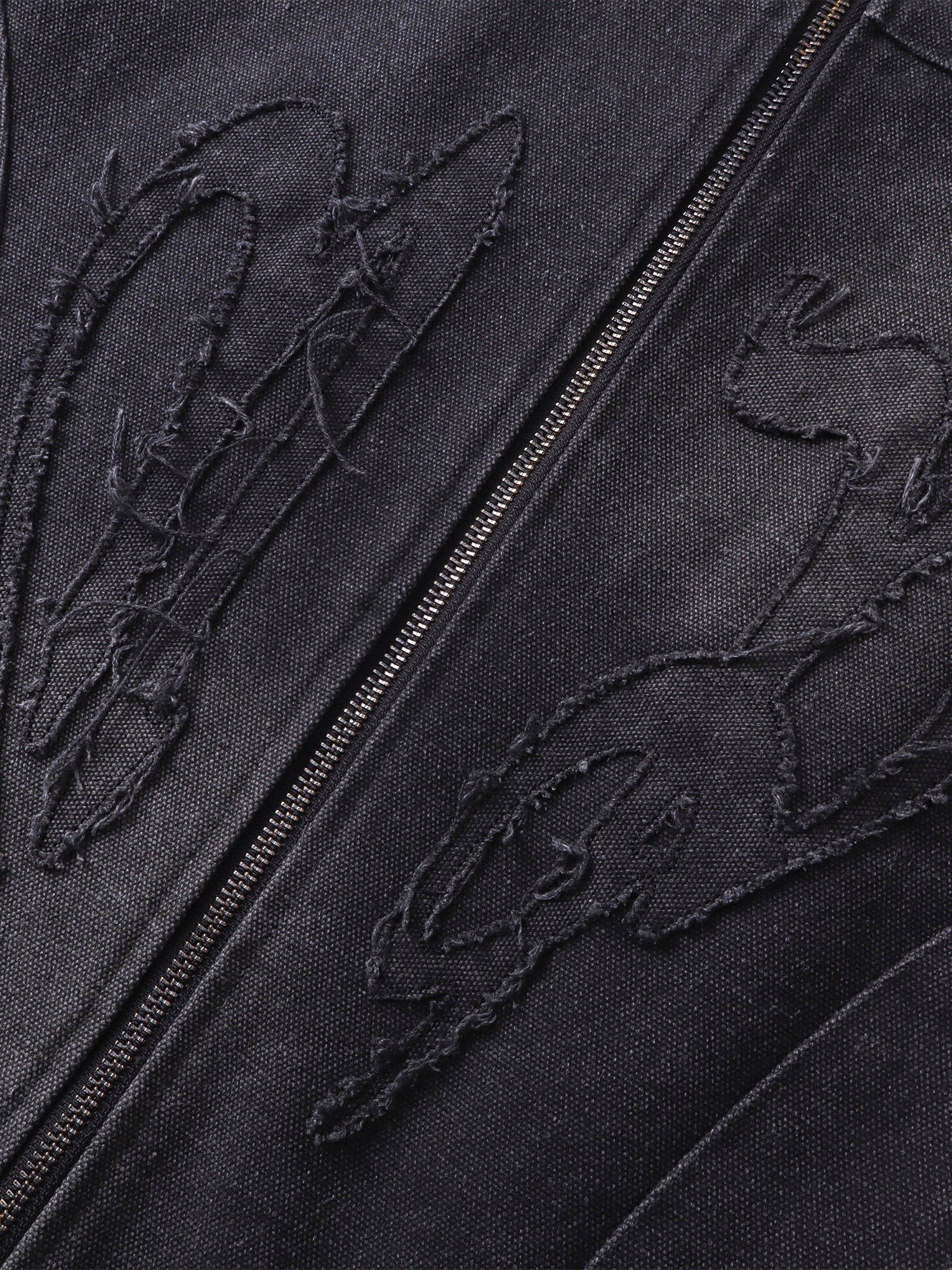 Close-up of the tonal self-fabric embroidery on TBHNP canvas moto jacket — men's streetwear detail