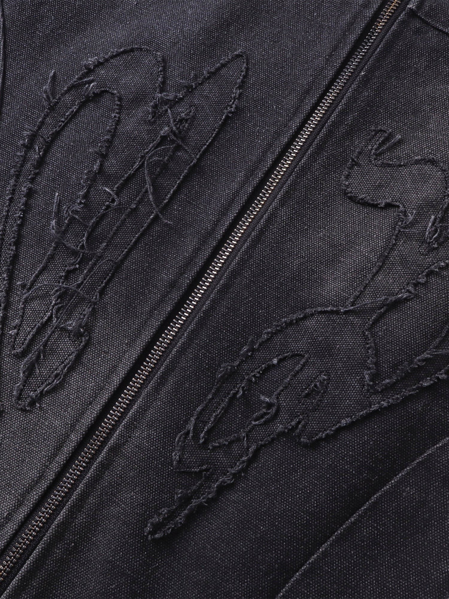 Close-up of the tonal self-fabric embroidery on TBHNP canvas moto jacket — men's streetwear detail