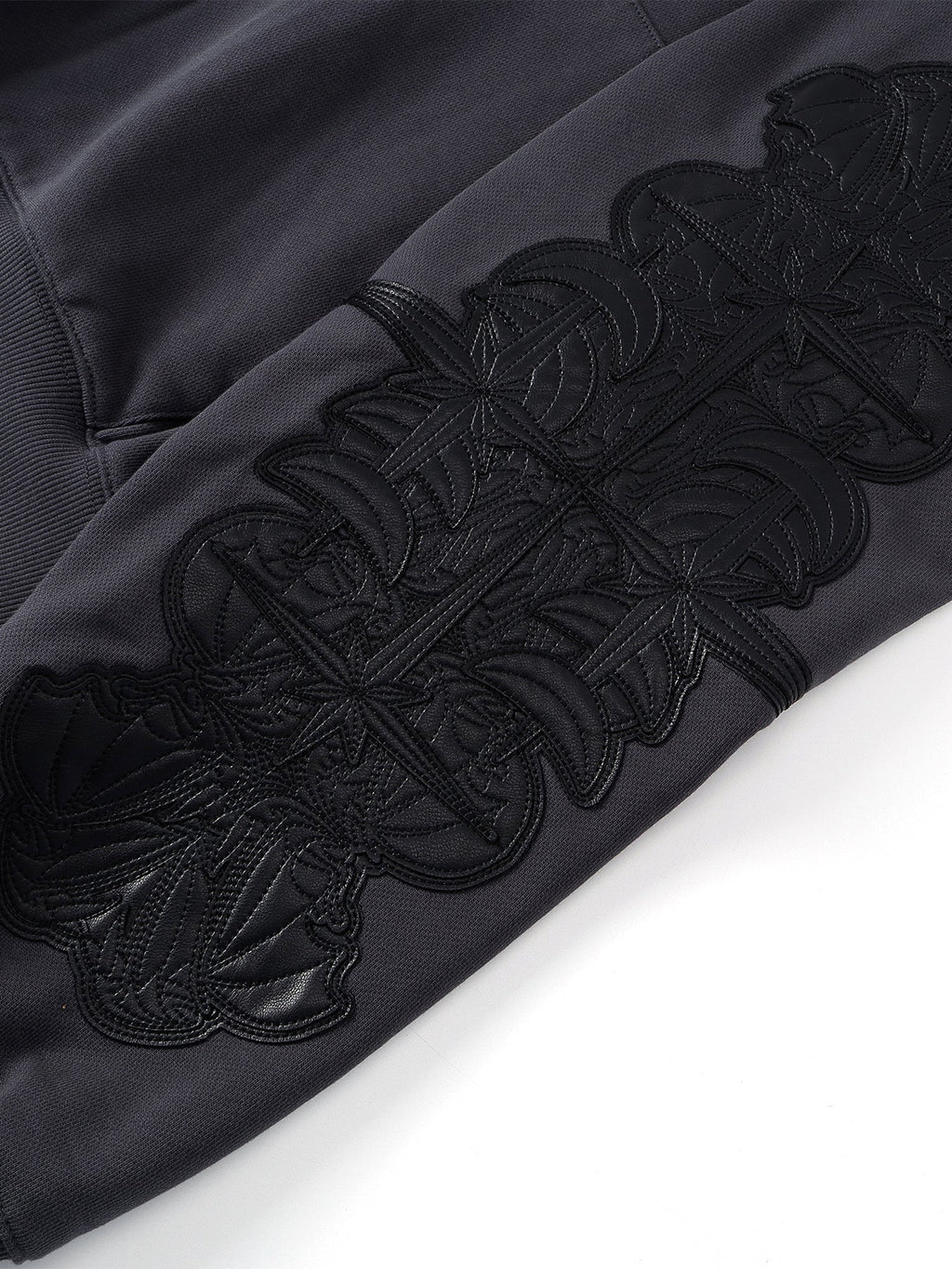 Close-up of the Black hoodie sleeve leather-patch embroidery.