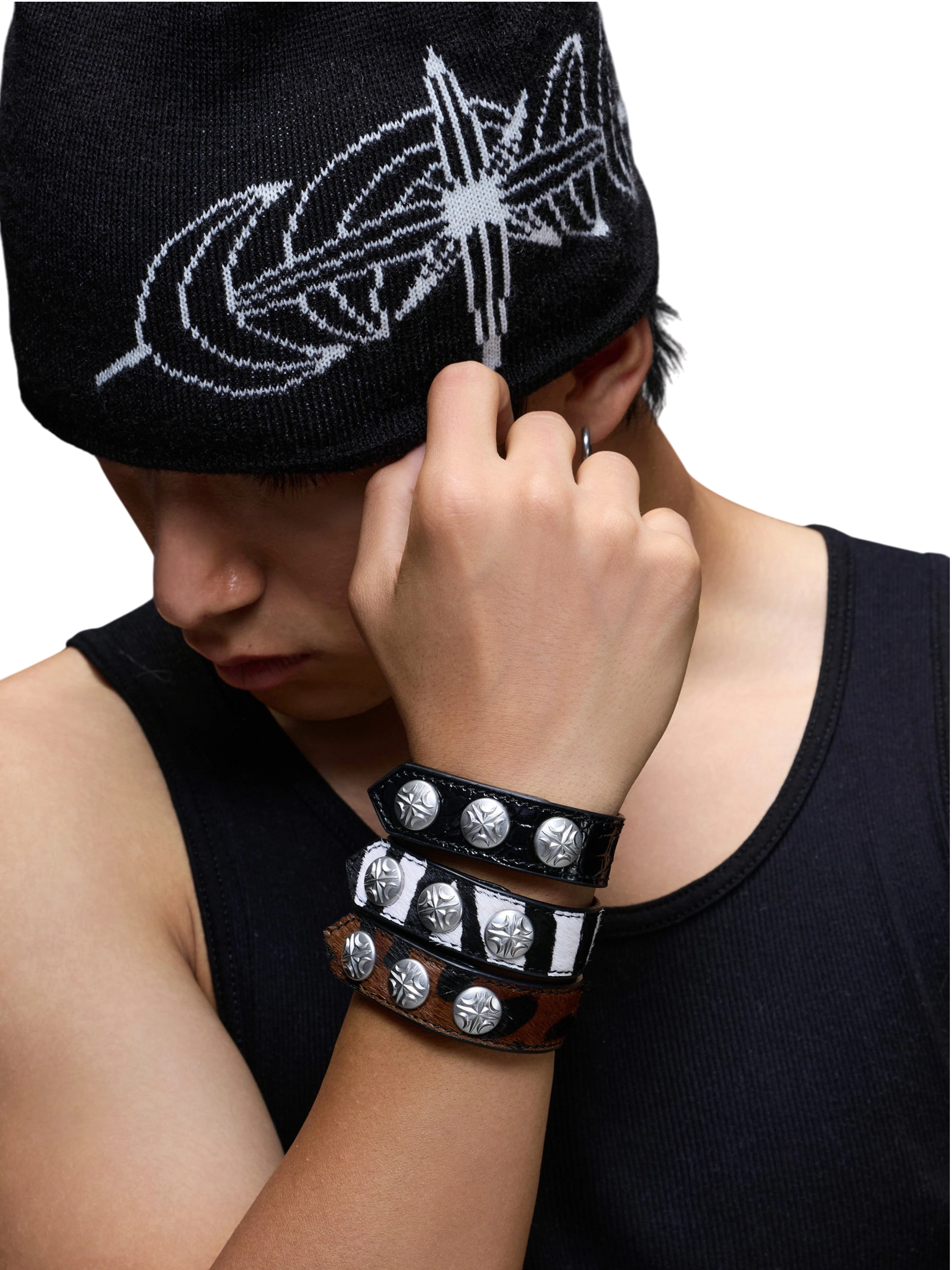 Model wearing stacked TBHNP leather bracelets with metal hardware.